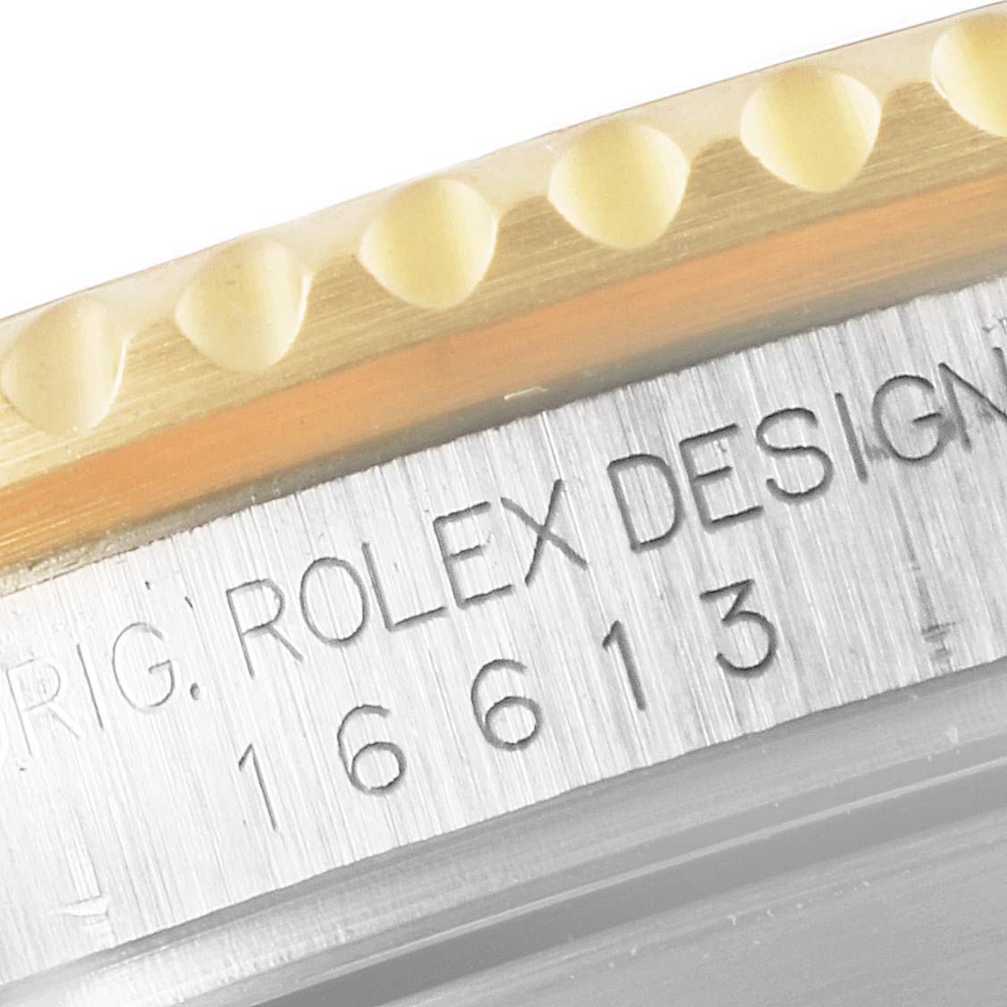 The image shows a close-up of the bezel and case band of a Rolex Submariner 16613 Men
s Steel and Gold (two tone) Blue Dial 16613 Men
s Steel and Gold (two tone) Blue Dial watch with engraved text.