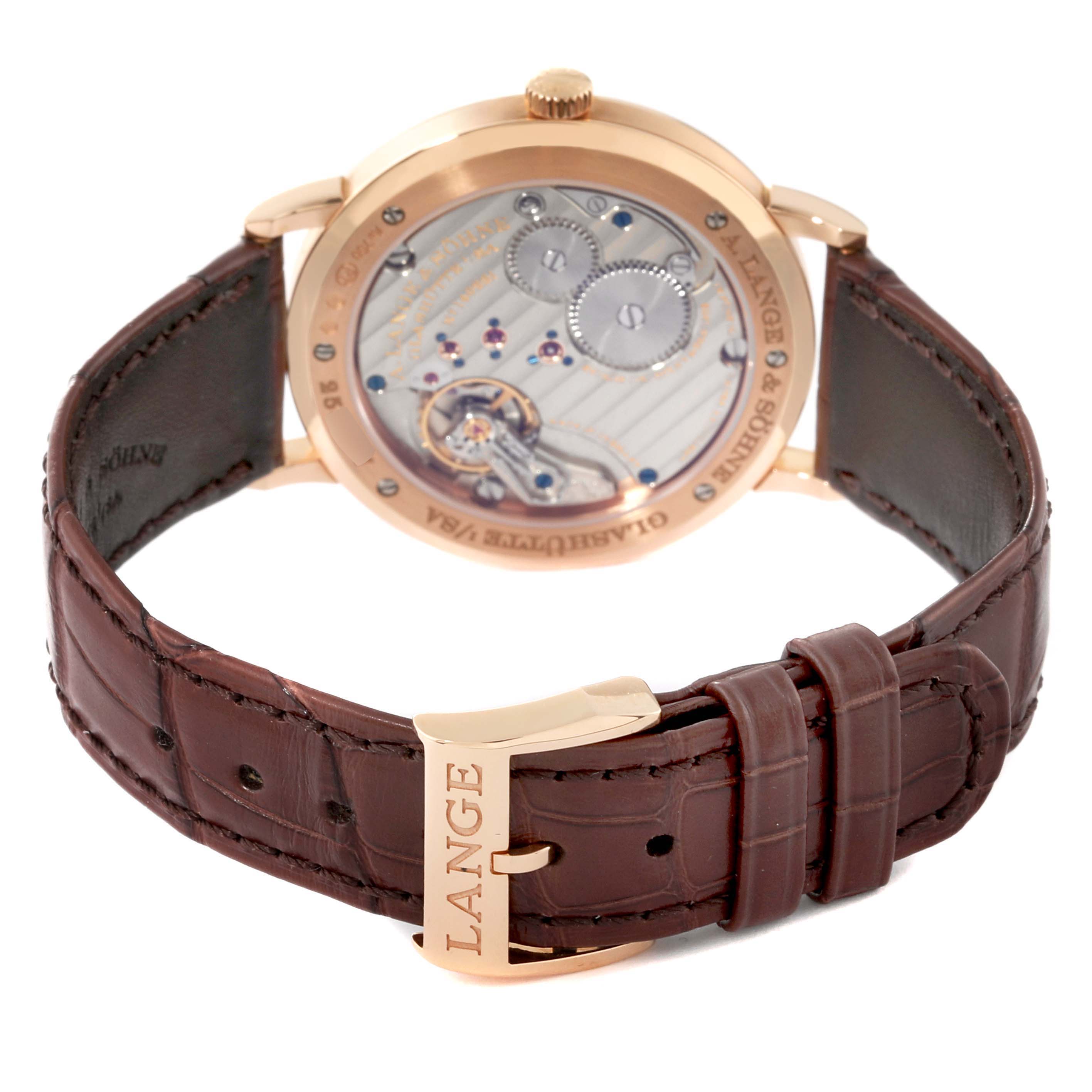 The image shows the back view of the A. Lange 
Sohne Saxonia 201.033 Men
s Rose Gold Silver Dial watch, highlighting its movement and leather strap with a "LANGE" buckle.
