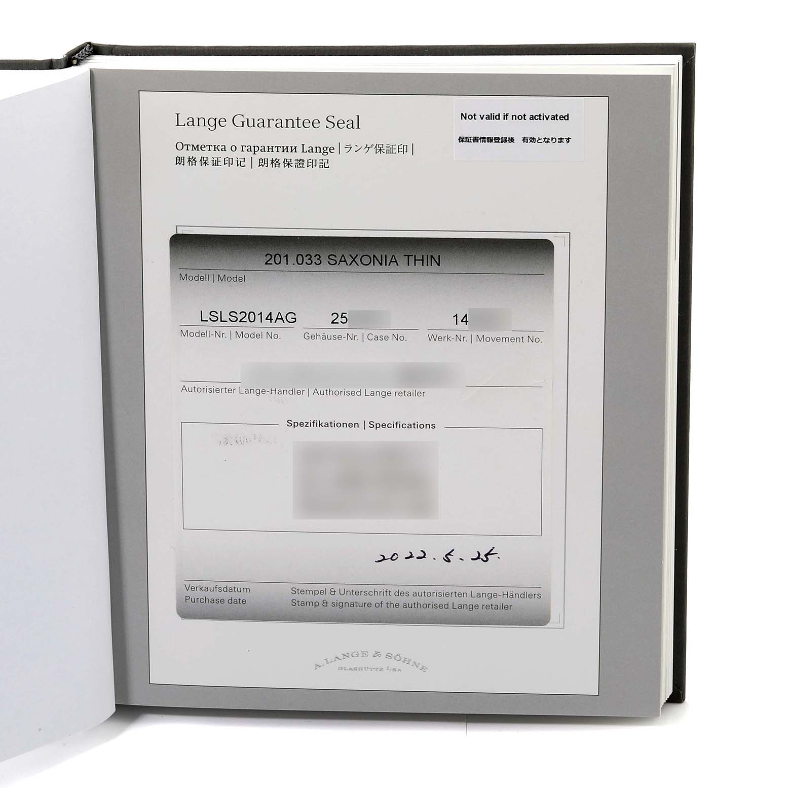 This image shows the certificate and guarantee card for the A. Lange 
Sohne Saxonia model watch, taken from a top angle.