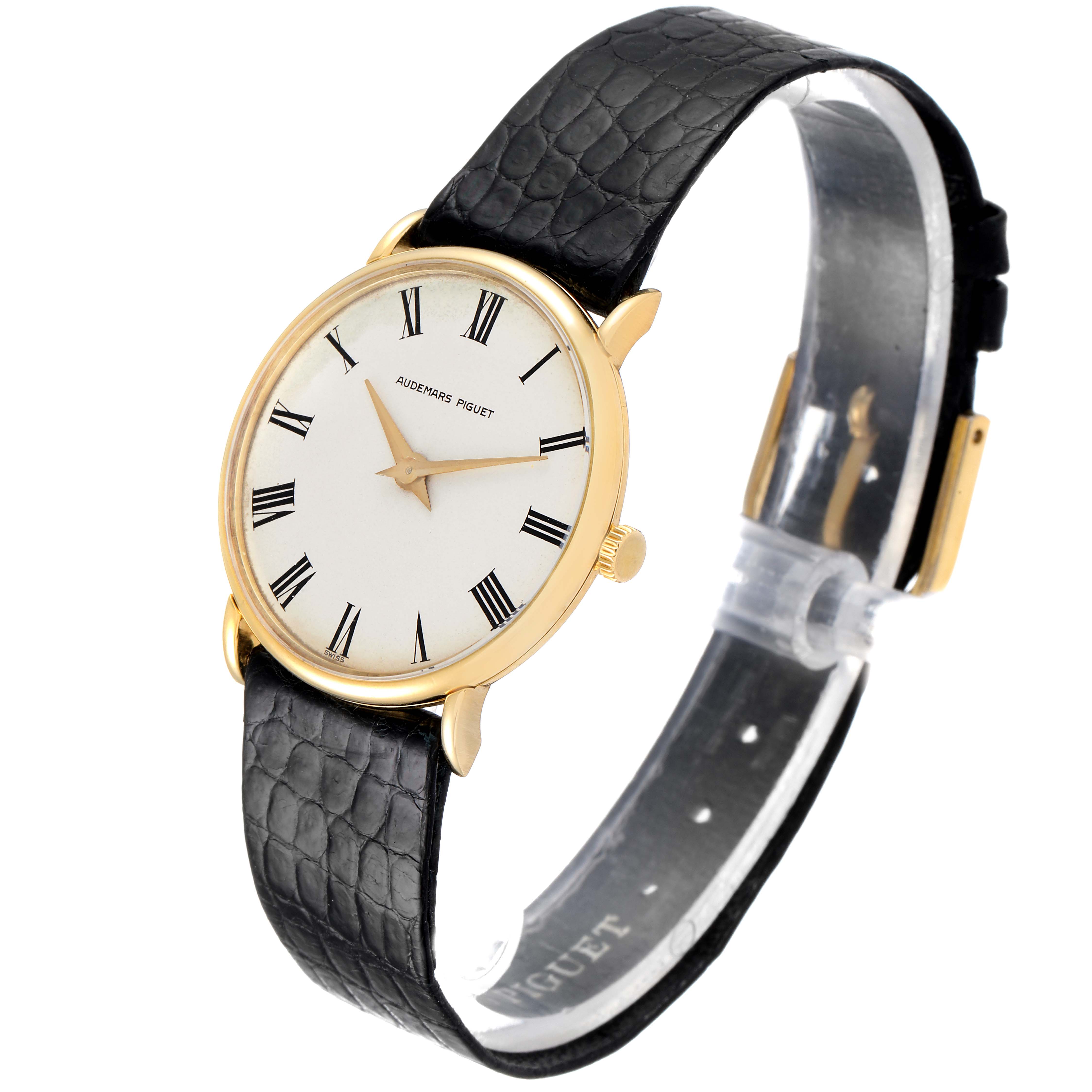 The image shows a Vintage Audemars Piguet watch from an angled side view, highlighting its round face, gold case, and black leather strap.