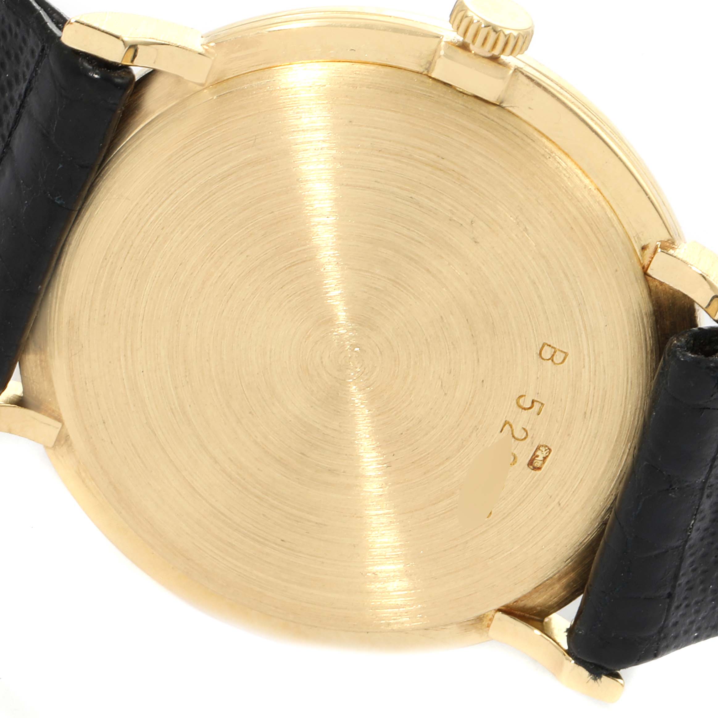 The image shows the case back of a vintage Audemars Piguet watch, with visible leather straps and the crown.