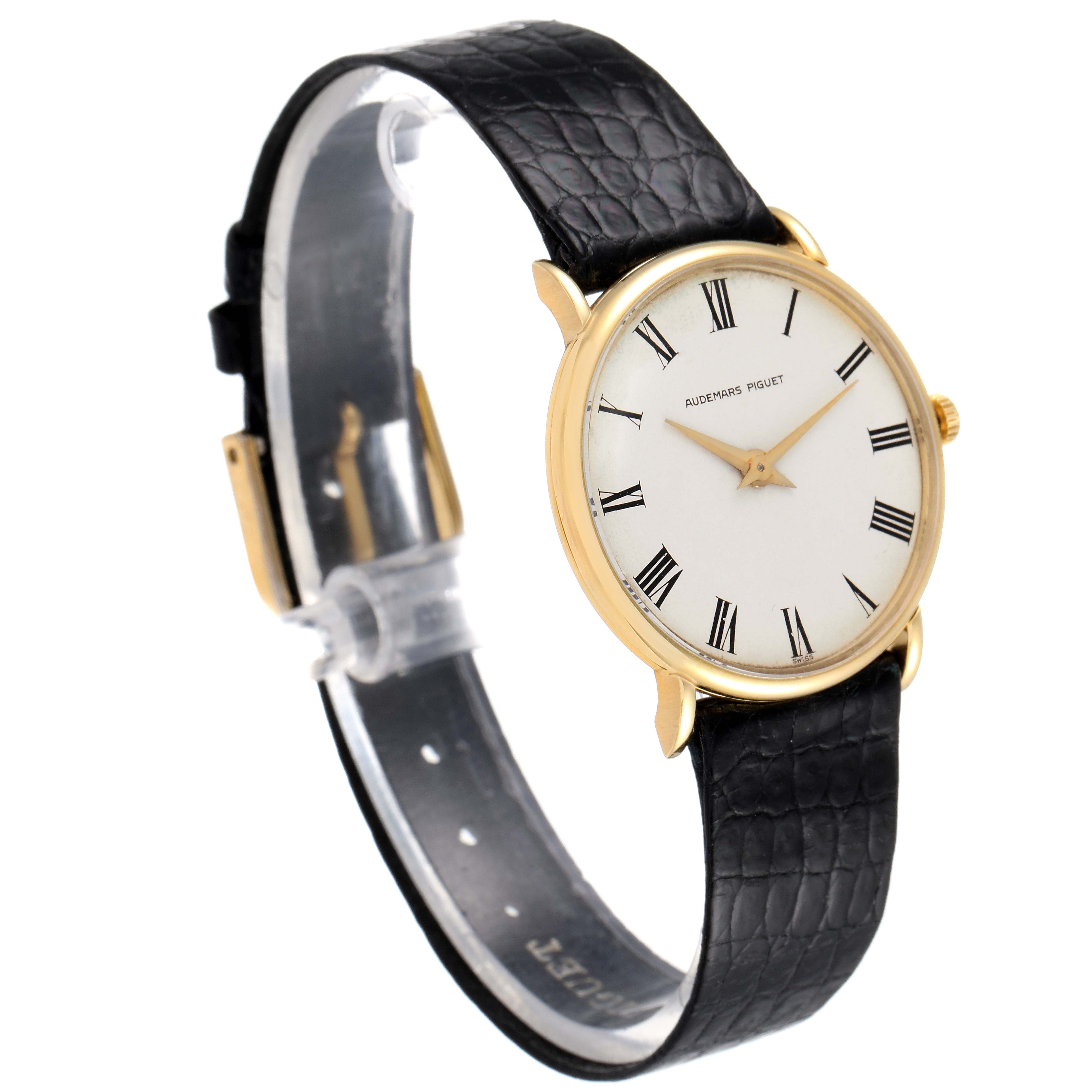 This image shows a side angle of a Vintage Audemars Piguet watch, featuring its round dial, black leather strap, and gold case.