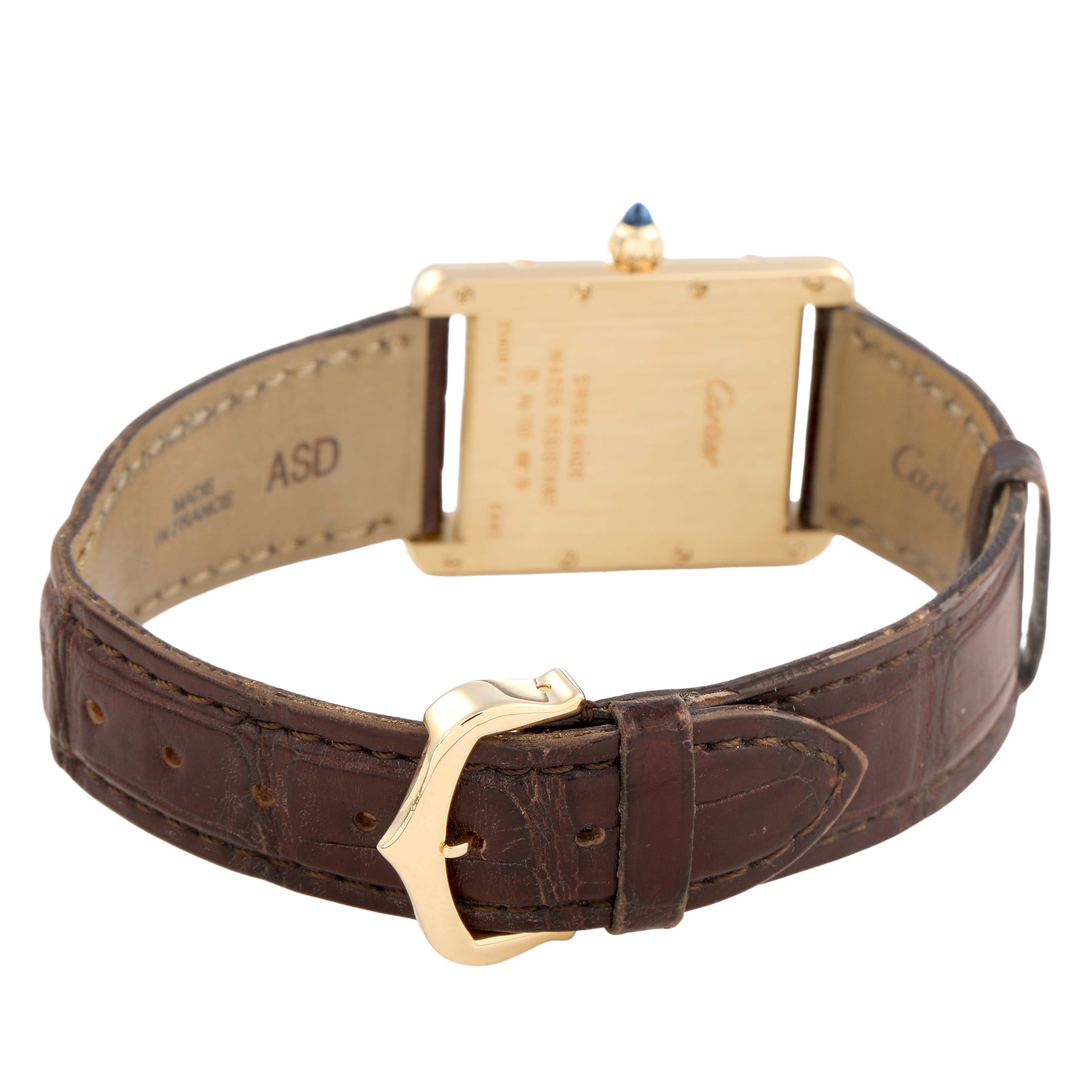 The image shows the back of the Tank Louis Cartier watch with its case and leather strap.