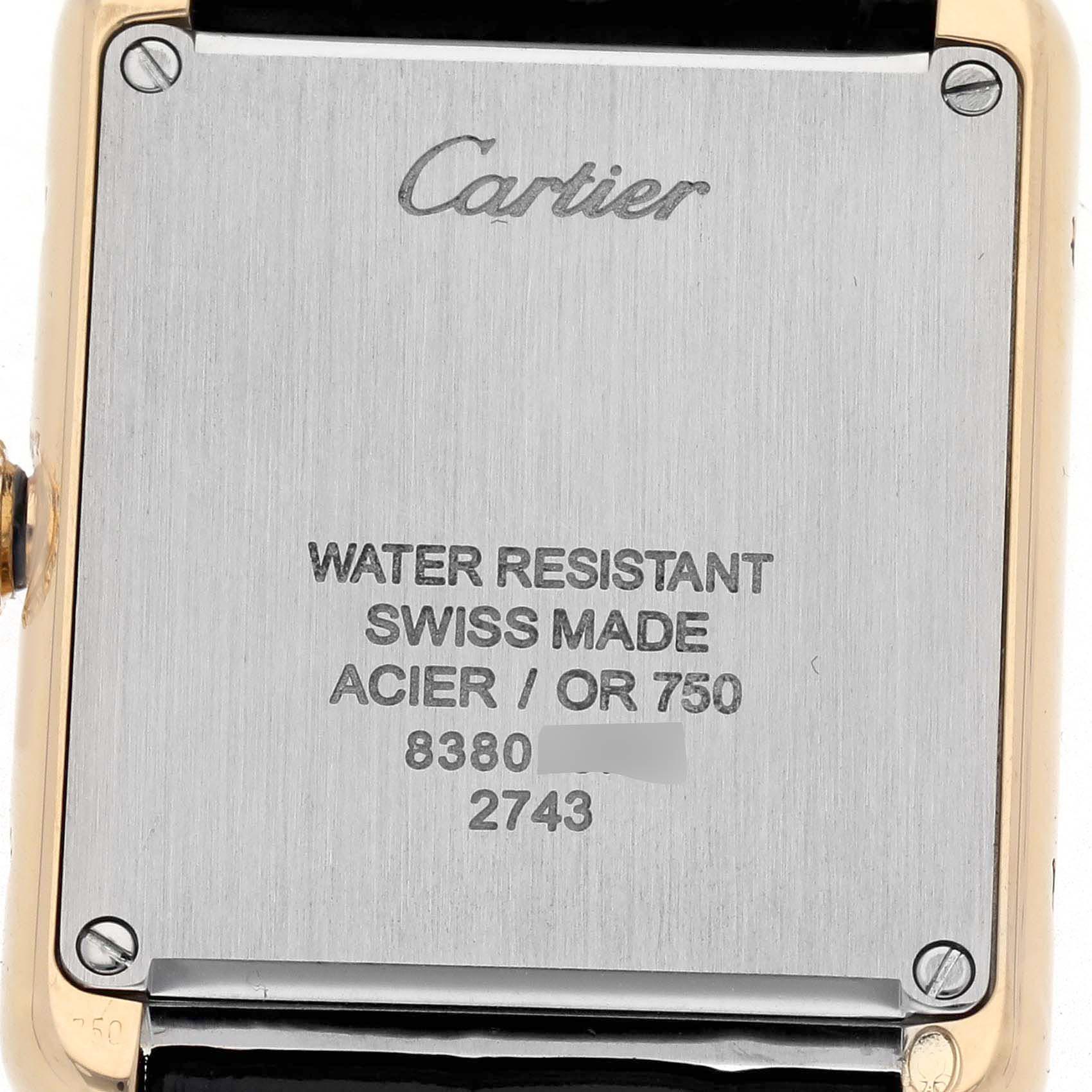 The image shows the back case of the Cartier Tank Solo W1018755 Women
s Yellow Gold Silver Dial W1018755 Women
s Yellow Gold Silver Dial watch, displaying engravings and screws at the center and corners.
