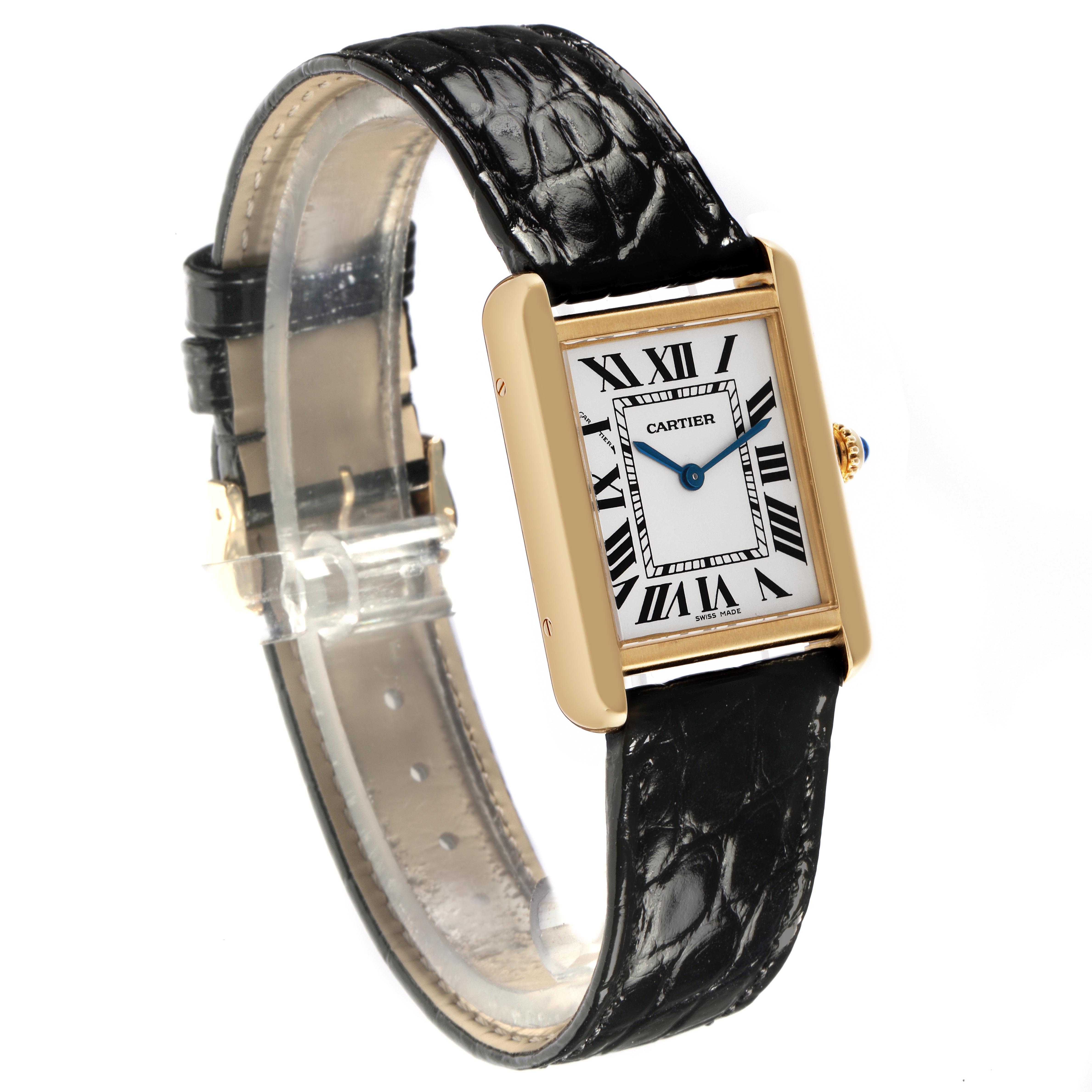The Cartier Tank Solo W1018755 Women
s Yellow Gold Silver Dial W1018755 Women
s Yellow Gold Silver Dial watch is shown at a three-quarter angle, highlighting the rectangular gold case, white dial with Roman numerals, and black leather strap.
