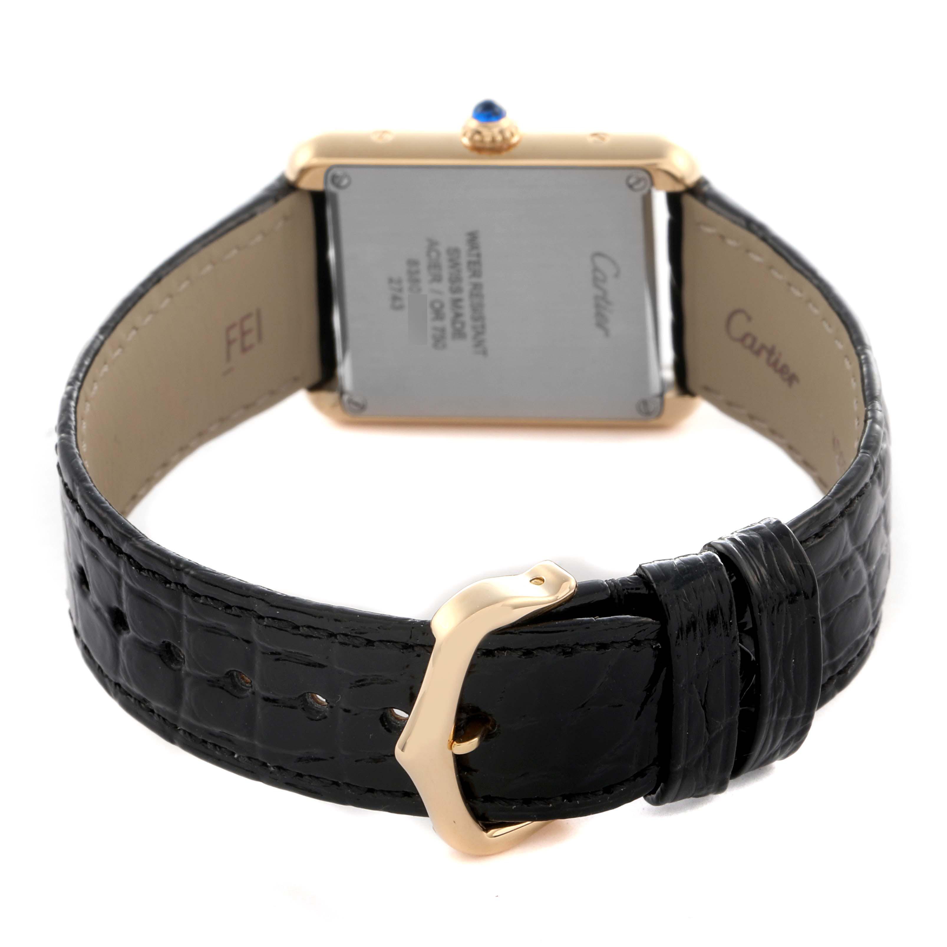 The Cartier Tank Solo W1018755 Women
s Yellow Gold Silver Dial W1018755 Women
s Yellow Gold Silver Dial watch is shown from the back, displaying the case, crown, and black leather strap with a gold buckle.