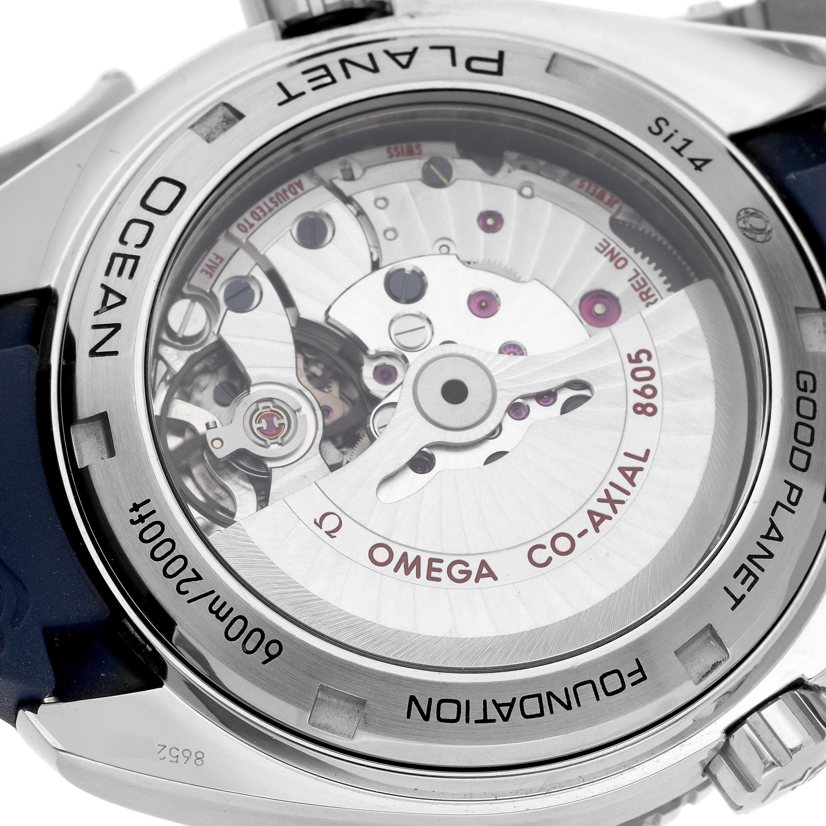 The image shows the back of an Omega Planet Ocean 232.32.44.22.03.001 Men's Stainless Steel Blue Dial 232.32.44.22.03.001 Men's Stainless Steel Blue Dial watch, highlighting its exposed Co-Axial 8605 movement.
