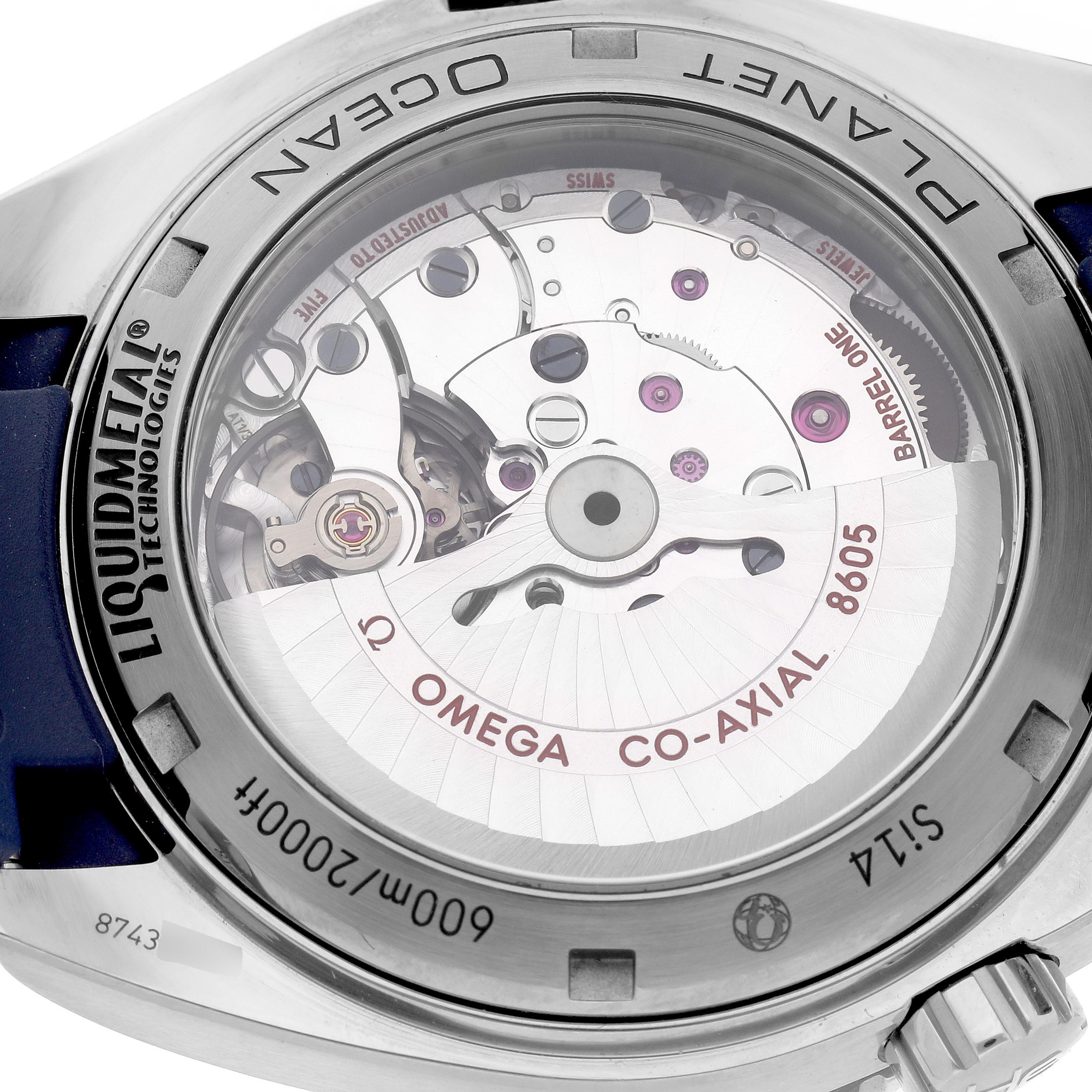 The image shows the back view of an Omega Planet Ocean 232.92.44.22.03.001 Men
s Stainless Steel Blue Dial 232.92.44.22.03.001 Men
s Stainless Steel Blue Dial watch, highlighting its exposed movement and "Liquidmetal" branding.
