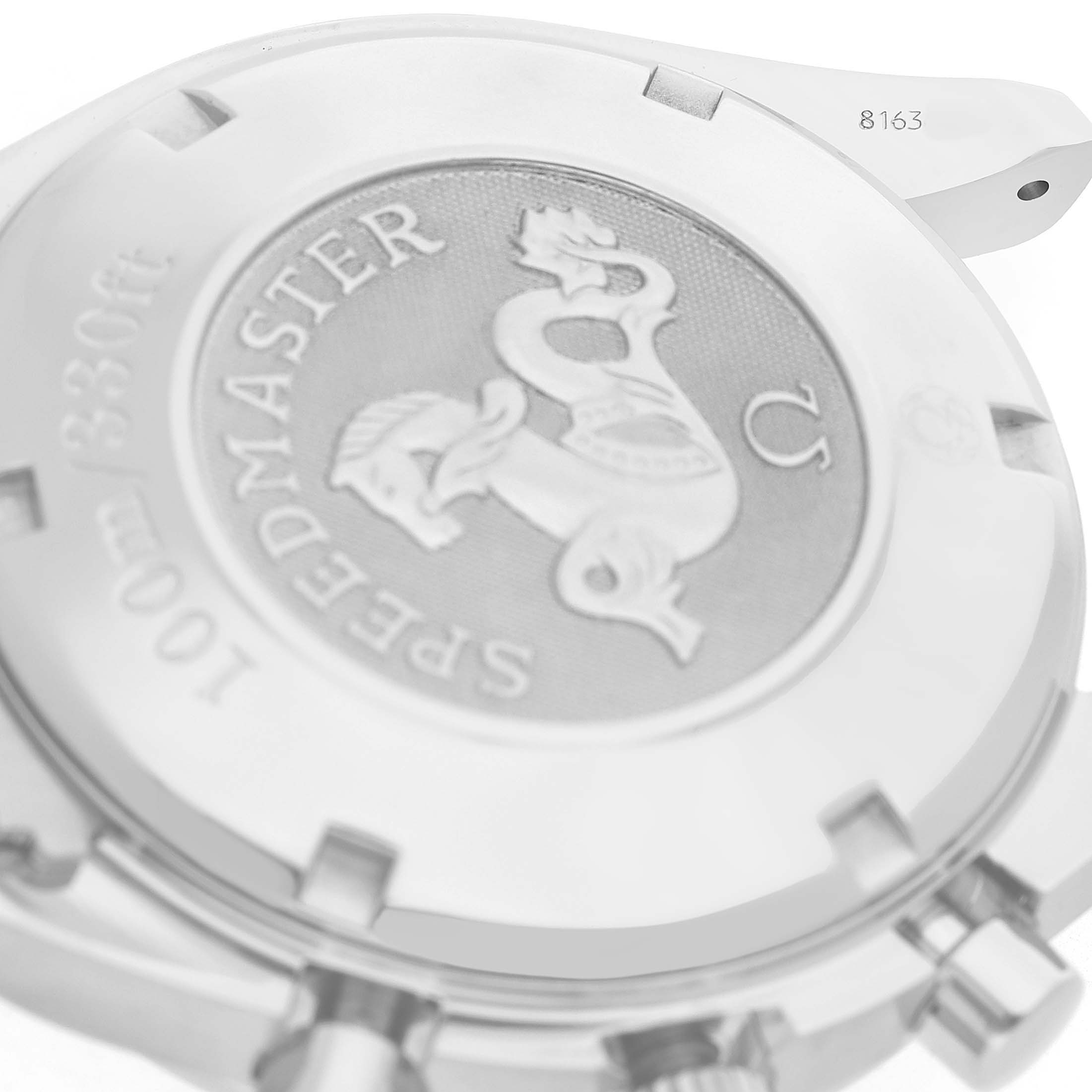 The image shows a close-up of the back casing of an Omega Speedmaster 3220.50.00 Men's Stainless Steel Black Dial watch, highlighting the embossed design and text.