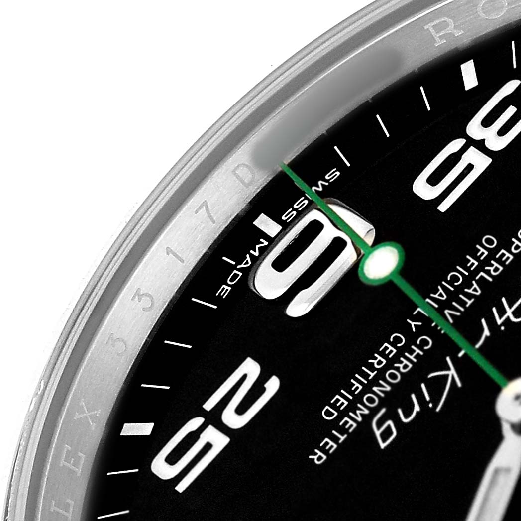 The image shows a close-up of the dial and bezel of a Rolex Air-King 116900 Men's Stainless Steel Black Dial watch, featuring numerals and part of the green second hand.