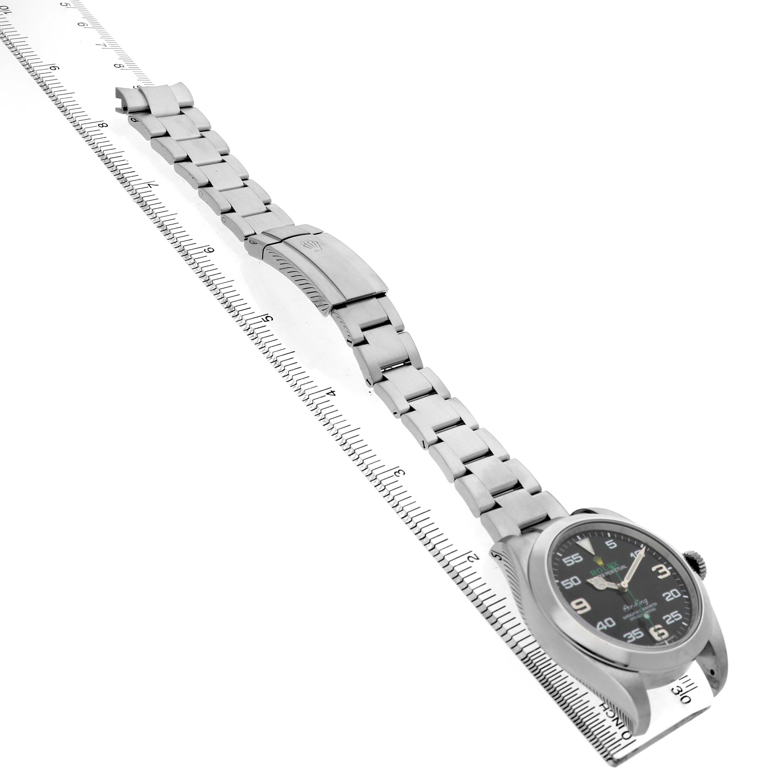 The image shows a Rolex Air-King 116900 Men's Stainless Steel Black Dial watch from a side perspective, emphasizing the bracelet and clasp along a ruler.