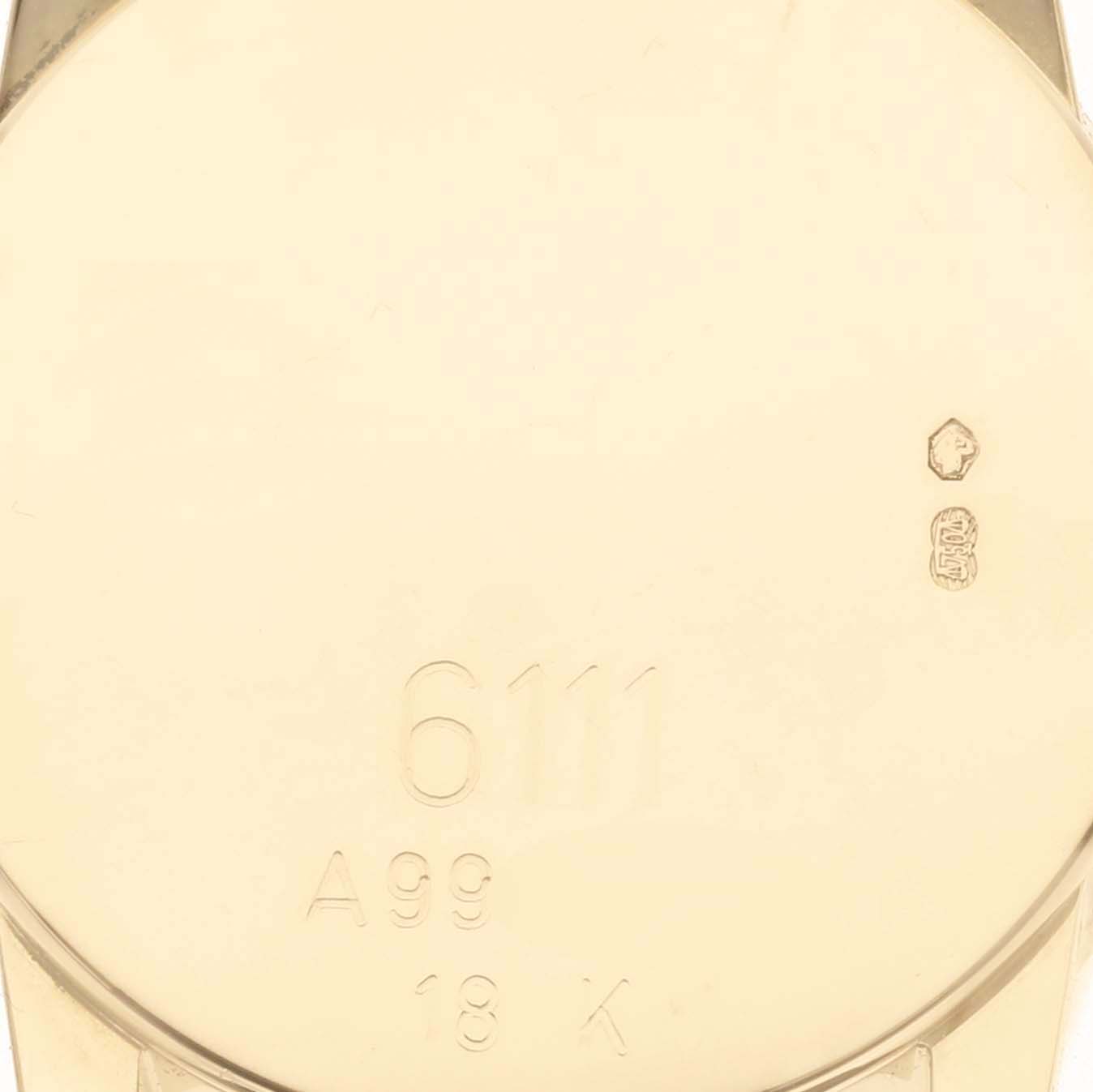 This image shows a close-up of the back of a Rolex Cellini 6111/8 Women
s Yellow Gold Black Dial 6111/8 Women
s Yellow Gold Black Dial watch, featuring engraved markings and stamps.