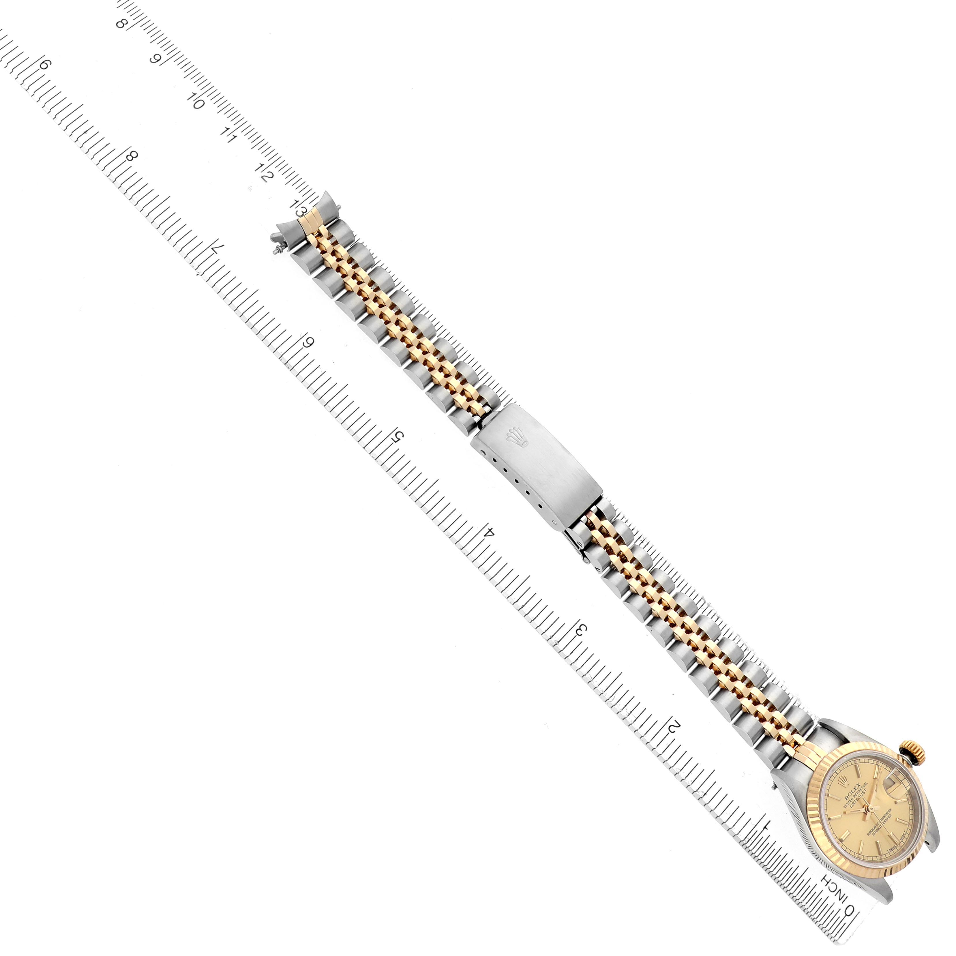 The Rolex Datejust 69173 Women
s Steel and Gold (two tone) Champagne Dial 69173 Women
s Steel and Gold (two tone) Champagne Dial watch is shown from an overhead angle, highlighting the bracelet and face alongside a ruler for scale.