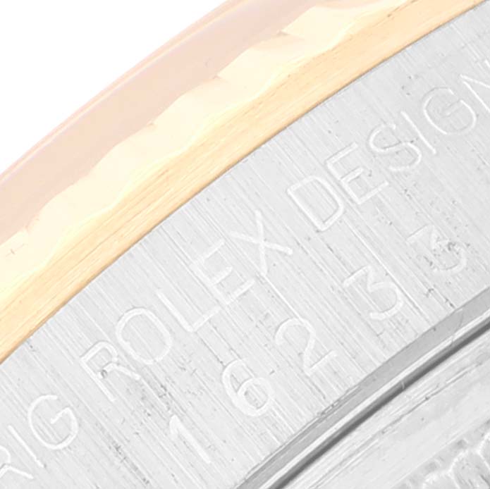 The image shows a close-up of the side edge and engraving on the bezel of a Rolex Datejust 16233 Men
s Steel and Gold (two tone) Champagne Dial 16233 Men
s Steel and Gold (two tone) Champagne Dial watch.