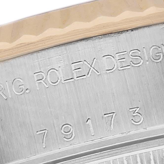 The image shows a close-up of a Rolex Datejust 79173 Women
s Steel and Gold (two tone) White Dial 79173 Women
s Steel and Gold (two tone) White Dial
s engraved outer rim, including part of its model number.