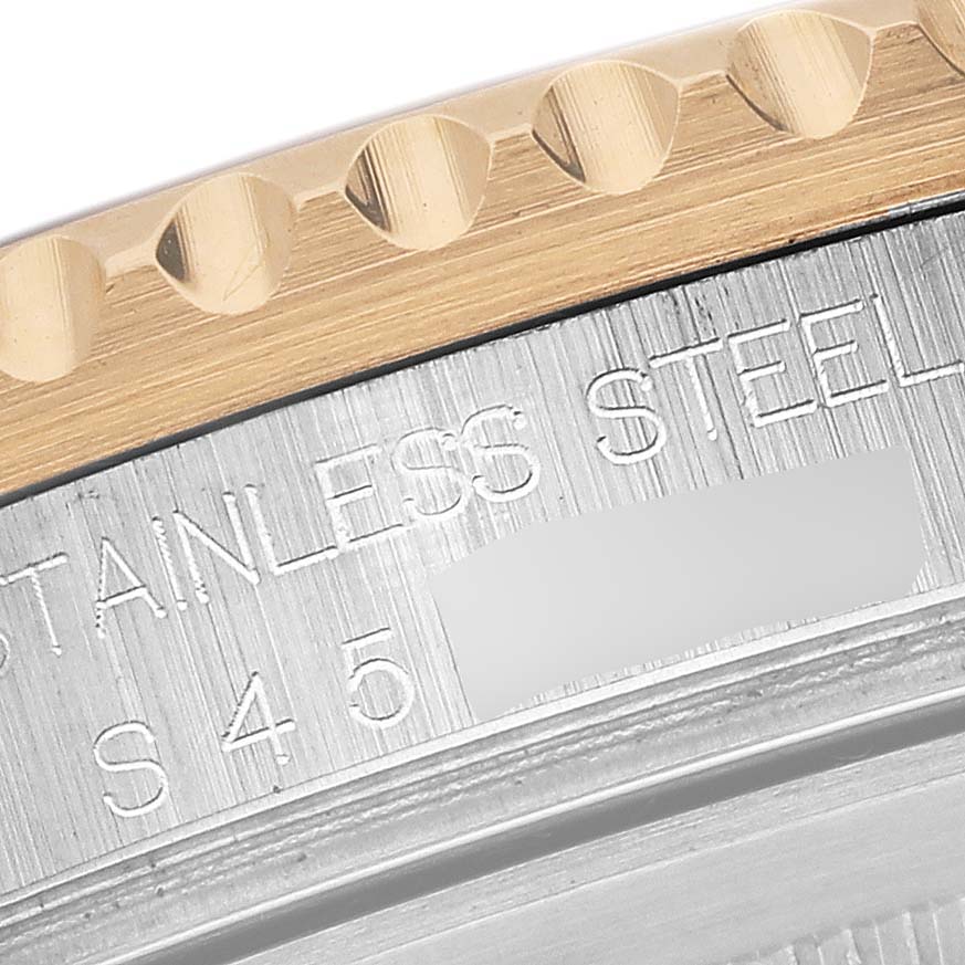 This close-up angle shows the side of the bezel and part of the case back of a Rolex GMT-Master 16713 Men
s Steel and Gold (two tone) Brown Dial 16713 Men
s Steel and Gold (two tone) Brown Dial, highlighting "STAINLESS STEEL."