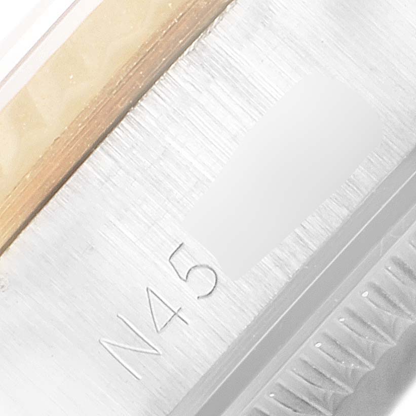 This close-up image of a Rolex Oyster Perpetual 67193 Women
s Steel and Gold (two tone) Champagne Dial 67193 Women
s Steel and Gold (two tone) Champagne Dial watch shows part of the bezel and engraved serial number.