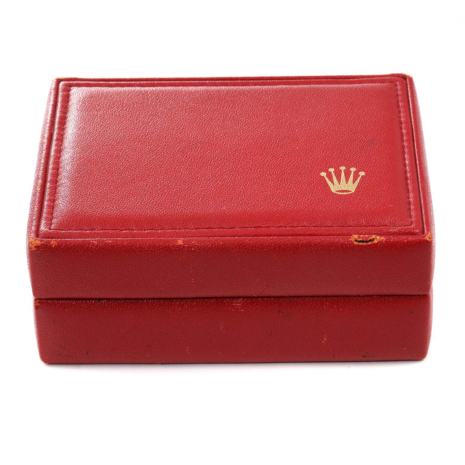 The image shows a red leather Rolex box for the Oyster Perpetual model, displaying the gold Rolex crown logo.