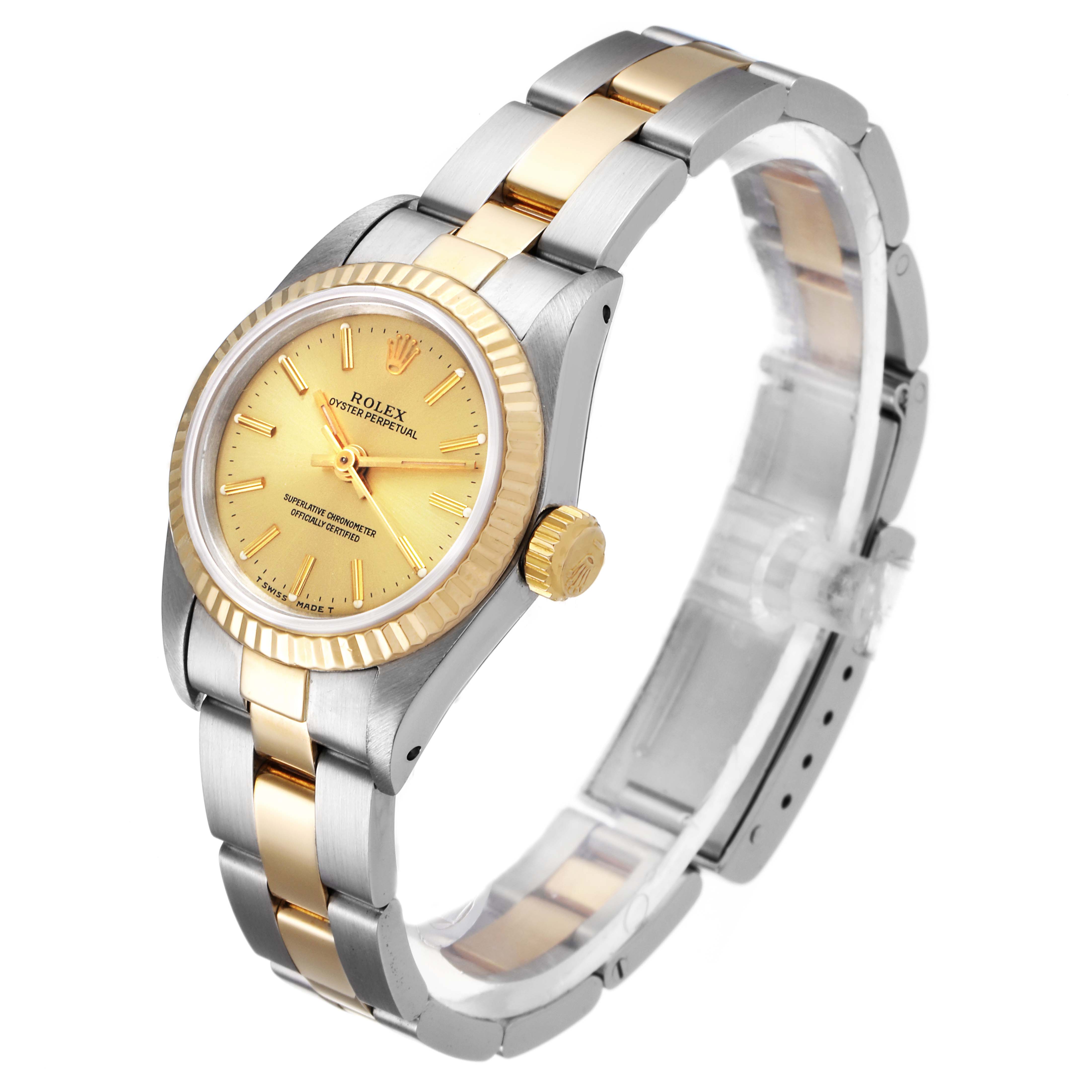 The Rolex Oyster Perpetual 67193 Women
s Steel and Gold (two tone) Champagne Dial 67193 Women
s Steel and Gold (two tone) Champagne Dial watch is shown at a 3/4 angle, displaying its gold dial, bezel, and two-tone metal bracelet.