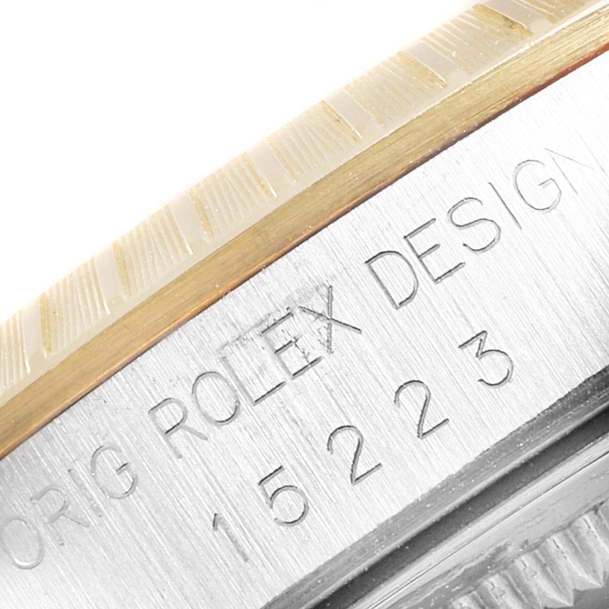 The image shows a close-up of the bezel and case side of a Rolex Date 15223 Men's Steel and Gold (two tone) Blue Dial 15223 Men's Steel and Gold (two tone) Blue Dial model, highlighting the engraved "ROLEX DESIGN" and model number.