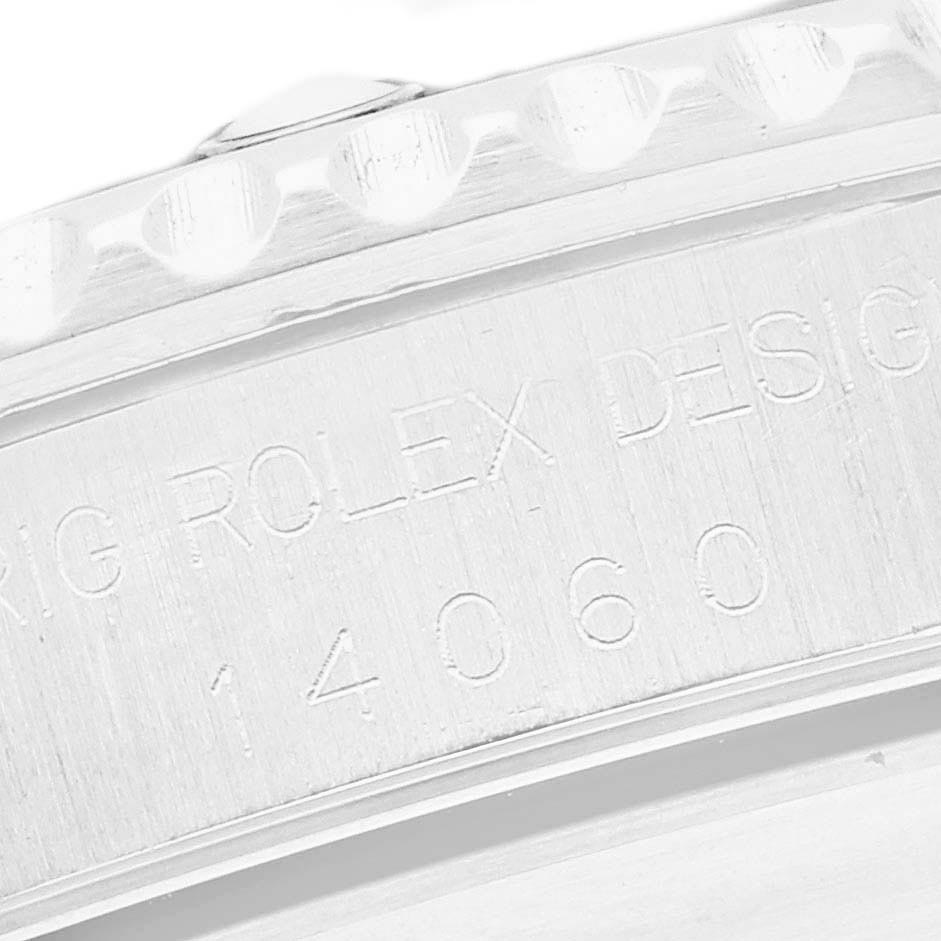 The image shows a close-up of the case side of a Rolex Submariner 14060 Men
s Stainless Steel Black Dial 14060 Men
s Stainless Steel Black Dial, highlighting engravings and part of the bezel edge.