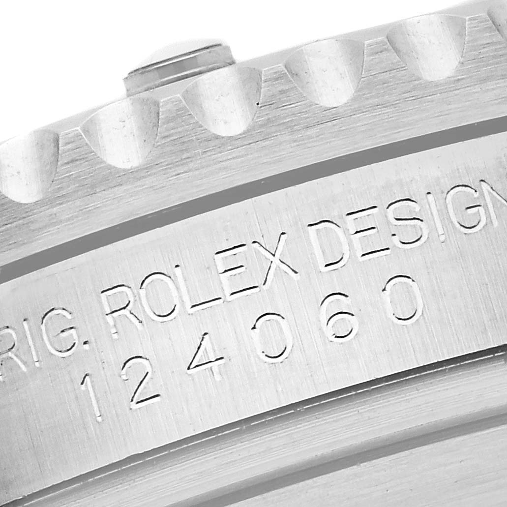 Close-up of a Rolex Submariner 124060 Men's Stainless Steel Black Dial 124060 Men's Stainless Steel Black Dial model 124060 showing the edge of the bezel and engraved model information.