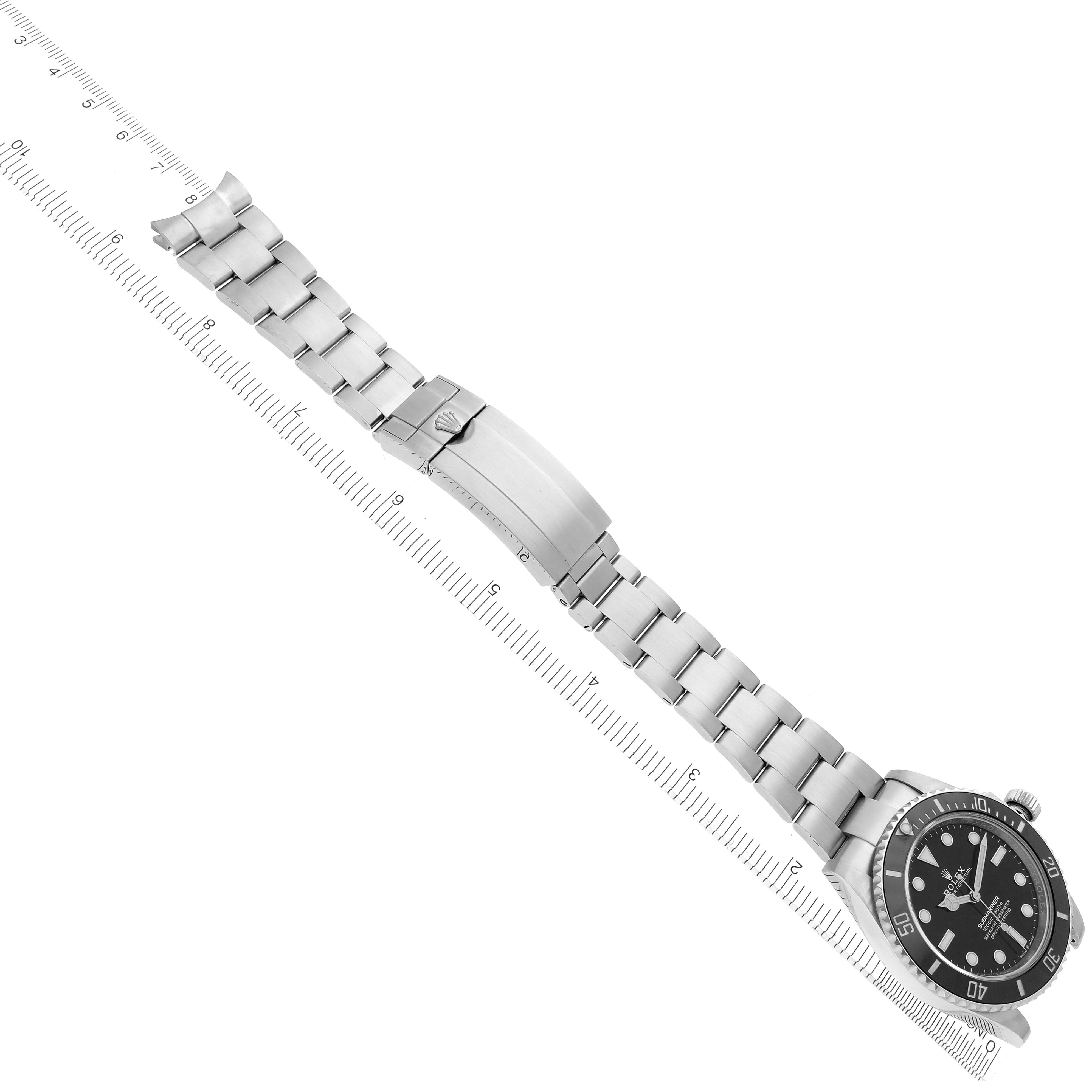 The image shows a top view of a Rolex Submariner 124060 Men
s Stainless Steel Black Dial 124060 Men
s Stainless Steel Black Dial watch with its bracelet fully extended alongside a ruler.