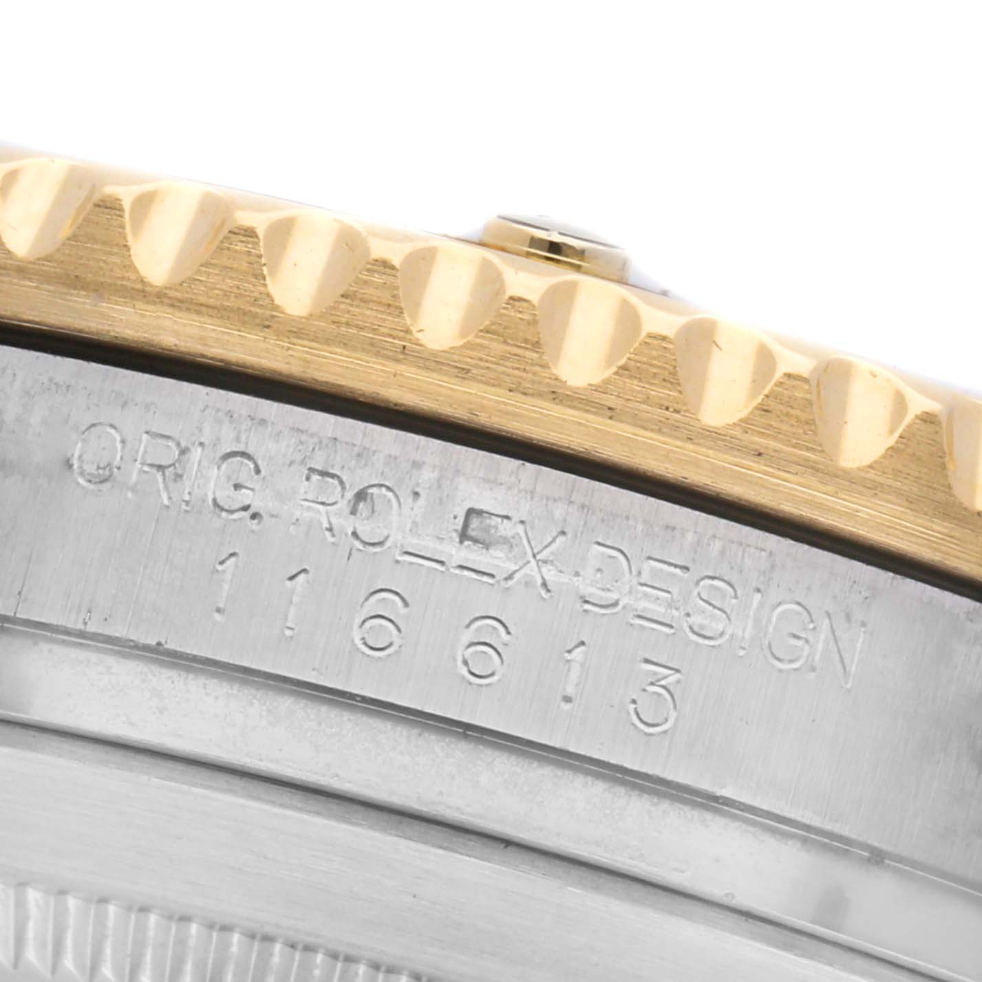 The image shows an angled close-up of the Rolex Submariner 116613 Men
s Steel and Gold (two tone) Black Dial 116613 Men
s Steel and Gold (two tone) Black Dial
s bezel and engraved case side.