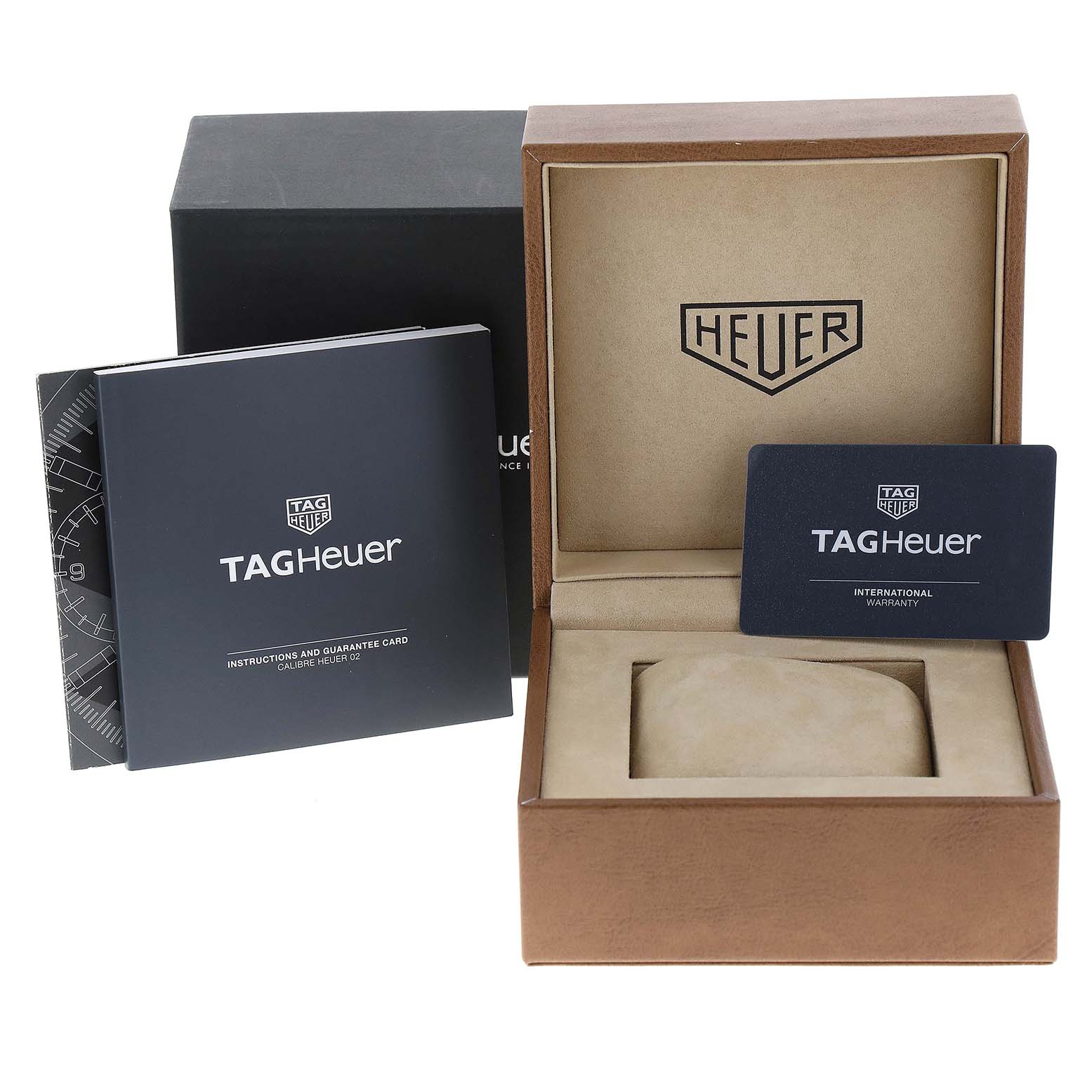 The image shows the Autavia model by Tag Heuer accessories, including the watch box, warranty card, and instruction manual, viewed from the front.