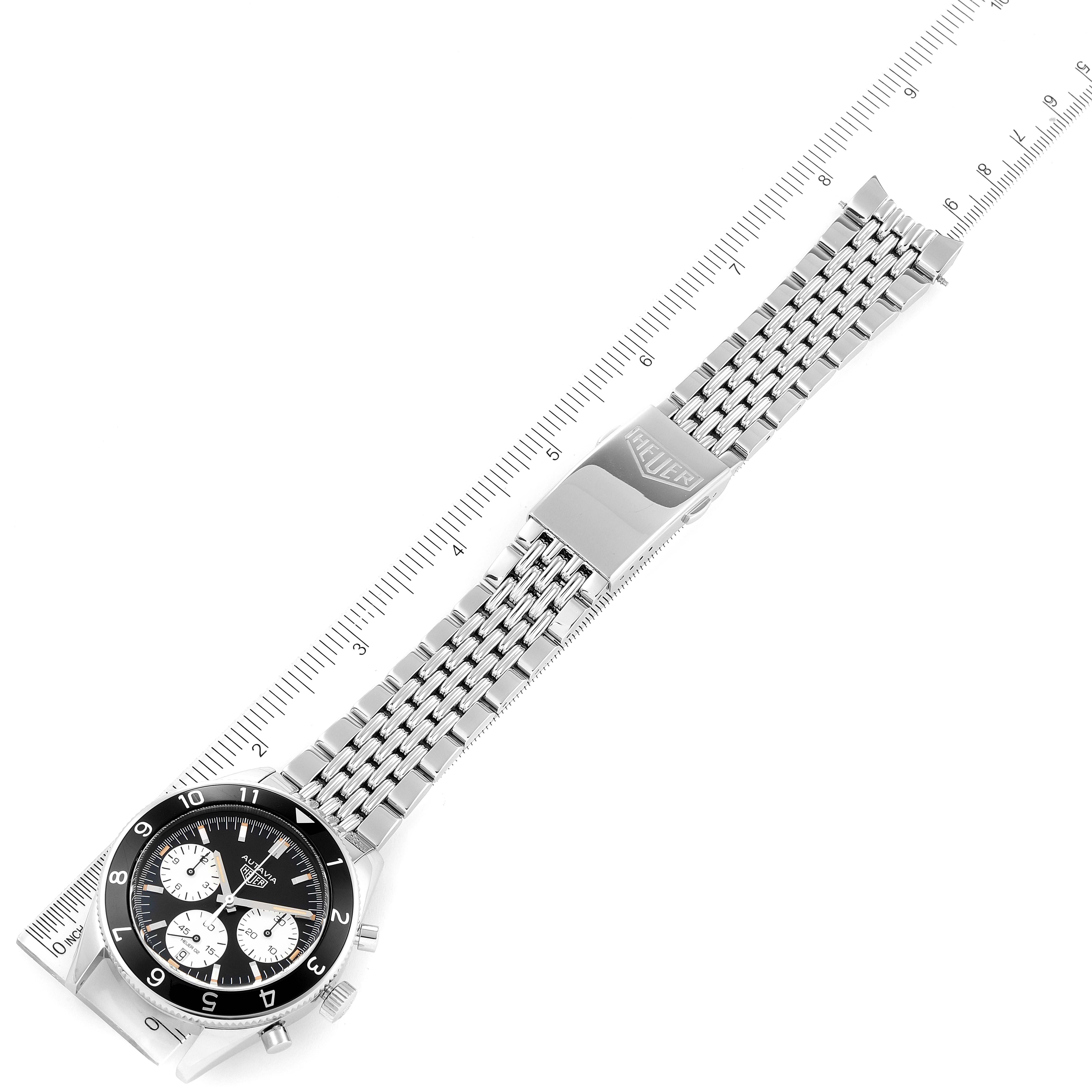The image shows a top-down view of a Tag Heuer Autavia CBE2110.BA0687 Men's Stainless Steel Black Dial CBE2110.BA0687 Men's Stainless Steel Black Dial watch, focusing on the watch face and metal bracelet against a ruler.