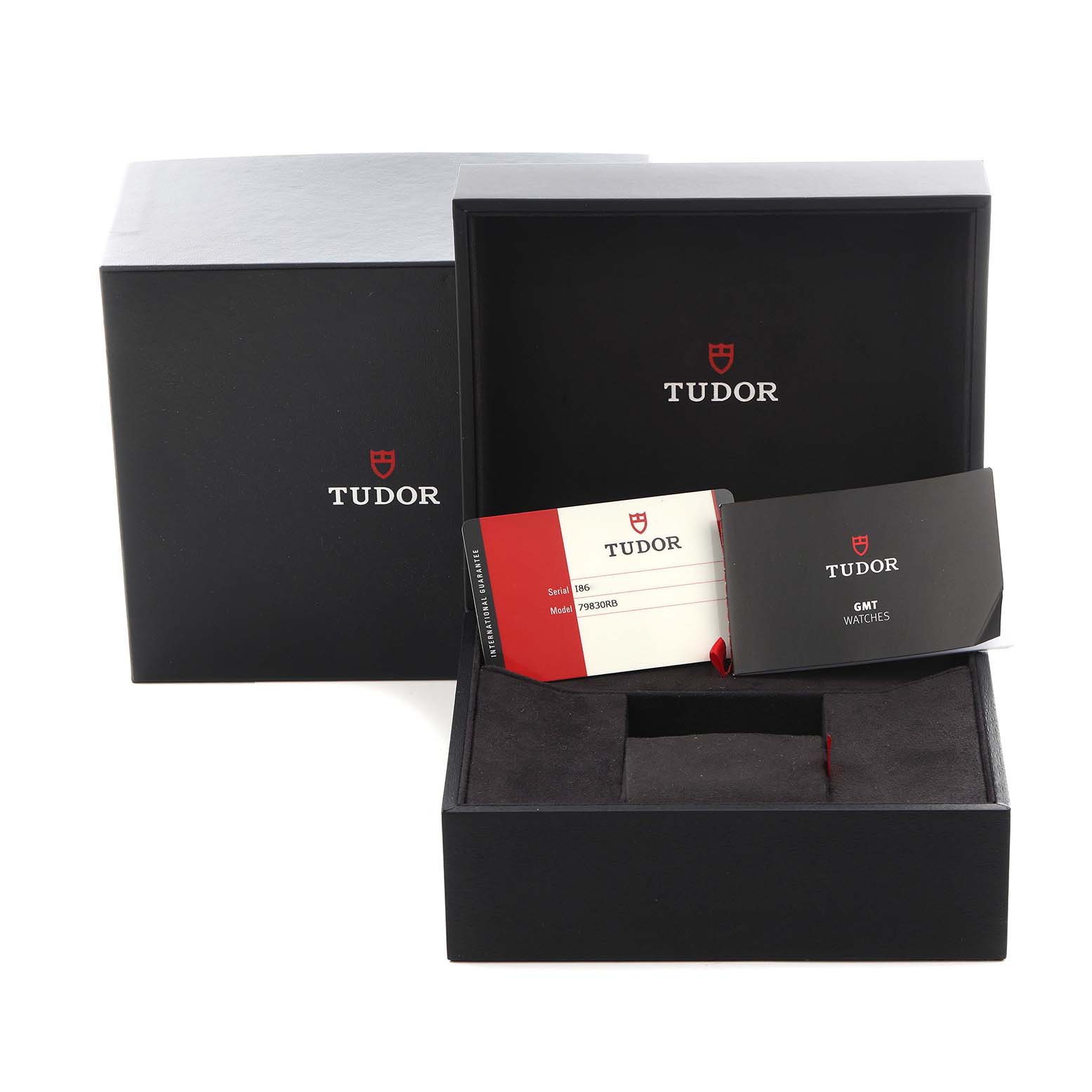 The image shows the Tudor Heritage Black Bay 79830RB Men
s Stainless Steel Black Dial 79830RB Men
s Stainless Steel Black Dial watch box and accessories from an angled top-down view, including documentation and a card.