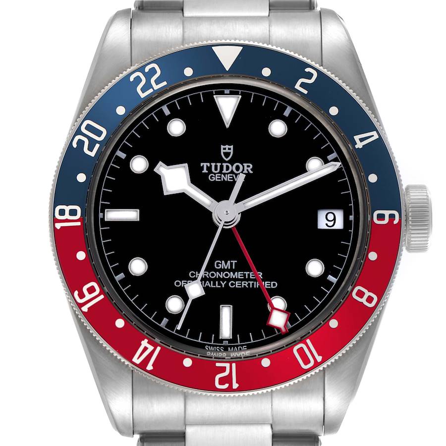 The Tudor Heritage Black Bay watch is shown from a top view, displaying the face, bezel, and part of the bracelet.