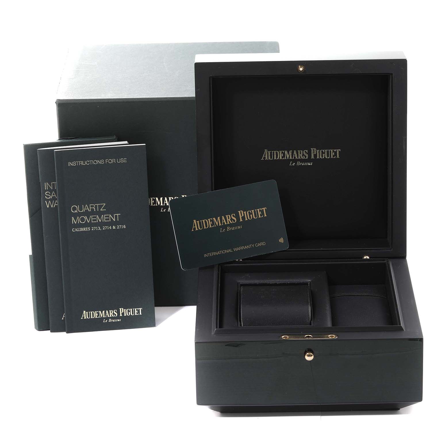 The image shows the packaging and accessories for an Audemars Piguet Royal Oak 67650ST.OO.1261ST.01 Women's Stainless Steel Black Dial 67650ST.OO.1261ST.01 Women's Stainless Steel Black Dial watch, including manuals, a warranty card, and a watch box.