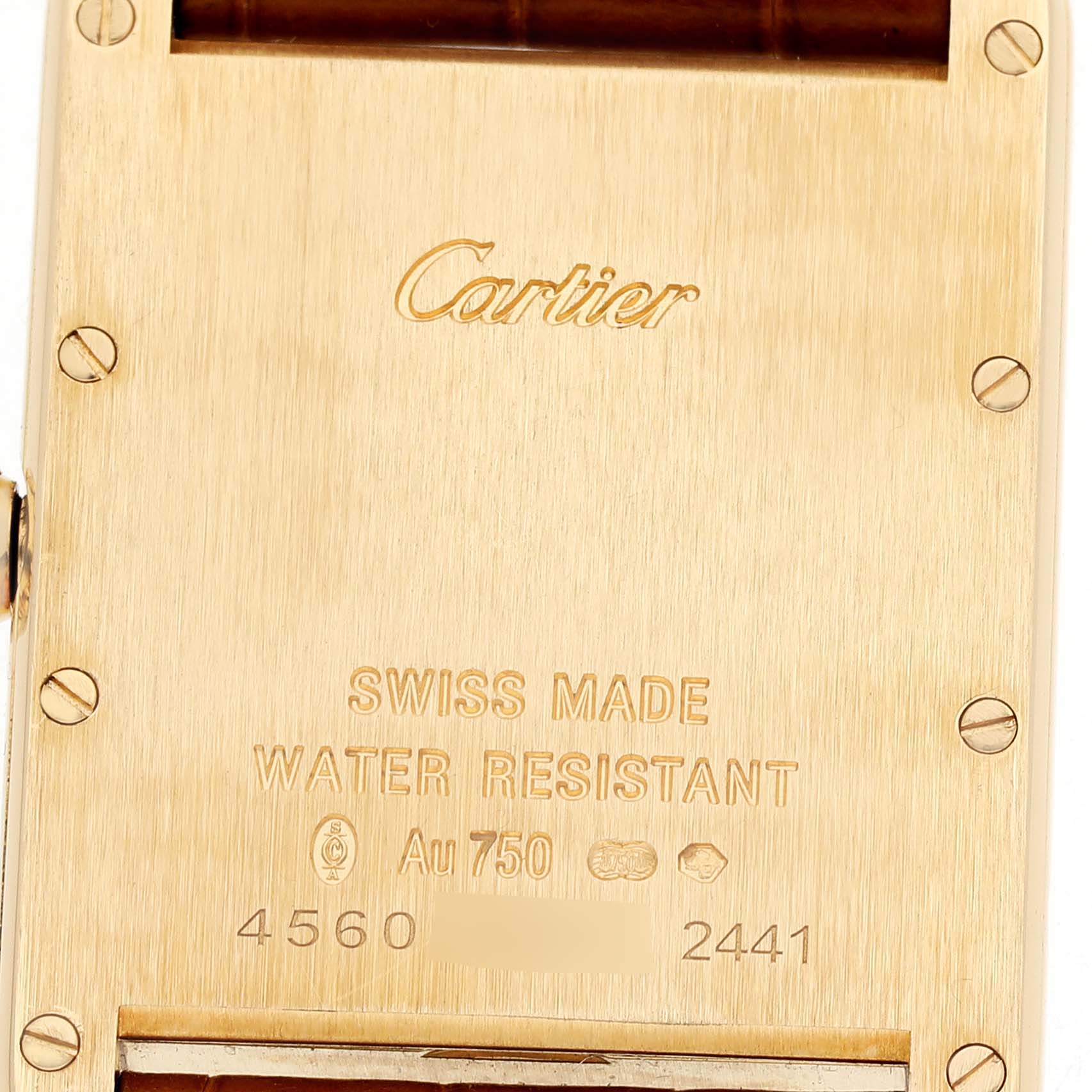 The image shows the back case of a Cartier Tank Louis W1529756 Men's Yellow Gold Silver Dial watch, featuring inscriptions and screws.