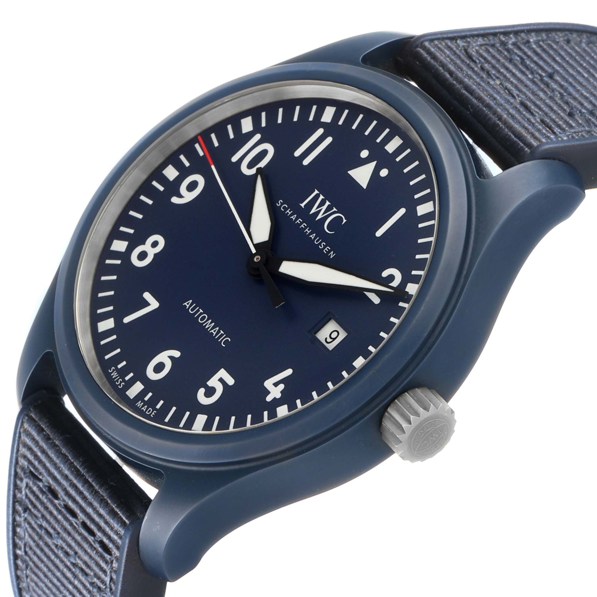 The IWC Pilot IW328101 Men's Ceramic Blue Dial watch is shown at a slight angle, highlighting its blue dial, white numerals, date window, and textured grey strap.