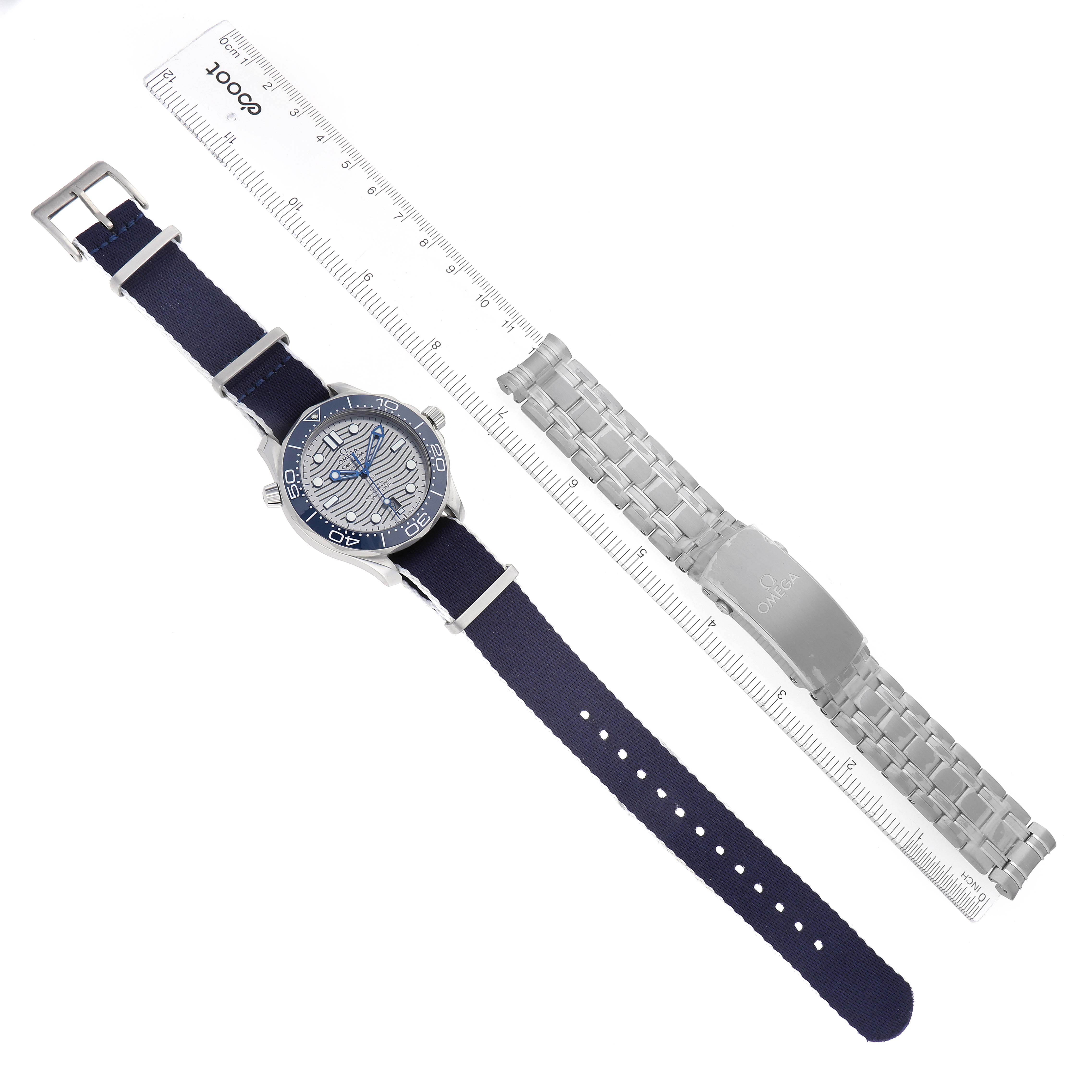 The Omega Seamaster 210.30.42.20.06.001 Men
s Stainless Steel Grey Dial 210.30.42.20.06.001 Men
s Stainless Steel Grey Dial watch is shown from a top-angle view with a blue strap and an additional metal bracelet beside it.