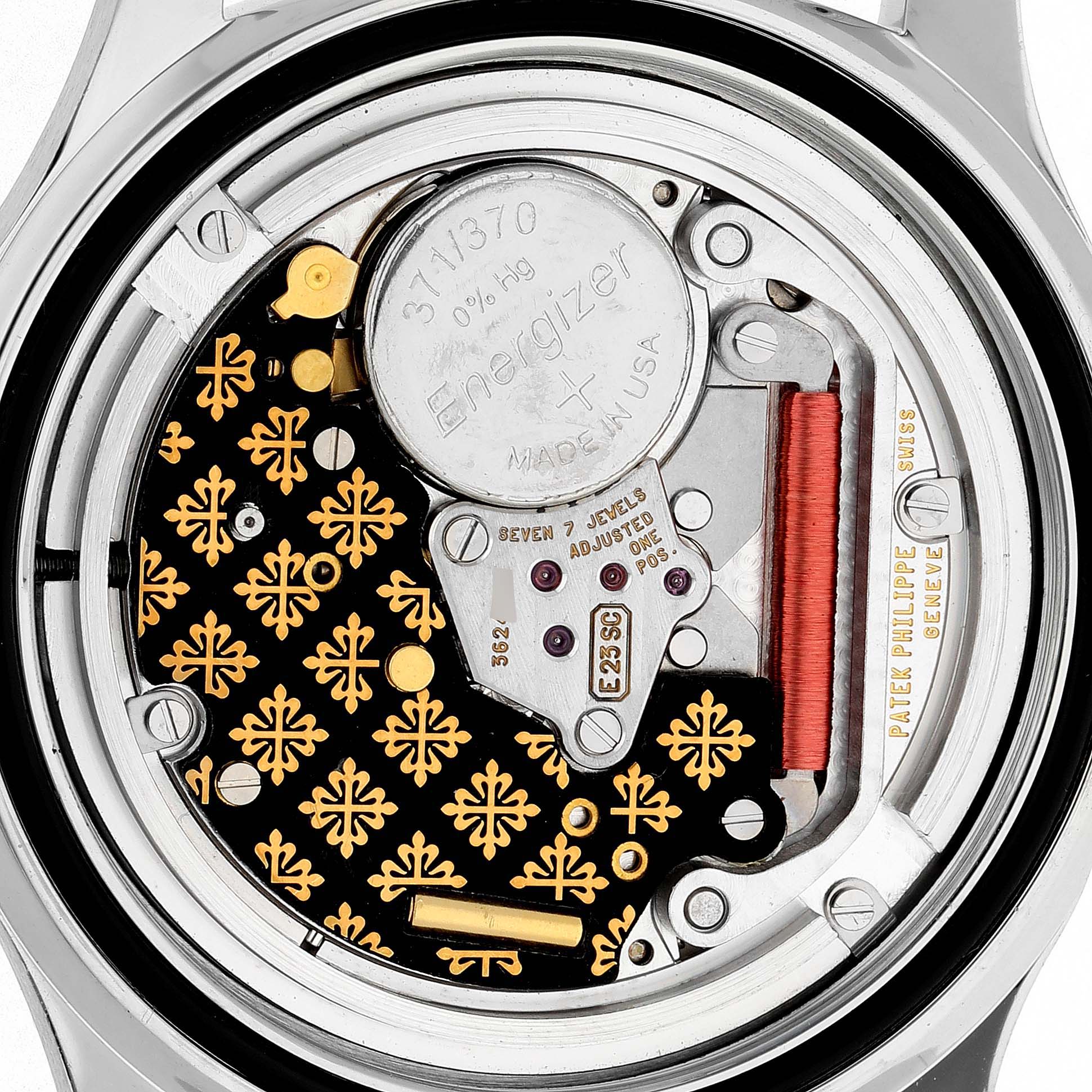The image shows a detailed view of the back of a Patek Philippe Aquanaut 5067A/011 Women's Stainless Steel White Dial, revealing its movement and battery.