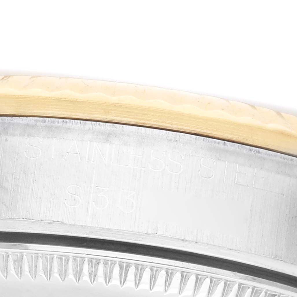 The image shows a close-up of the side of a Rolex Datejust 68273 Women's Steel and Gold (two tone) White Dial, focusing on the edge of the bezel and case with engraved text.