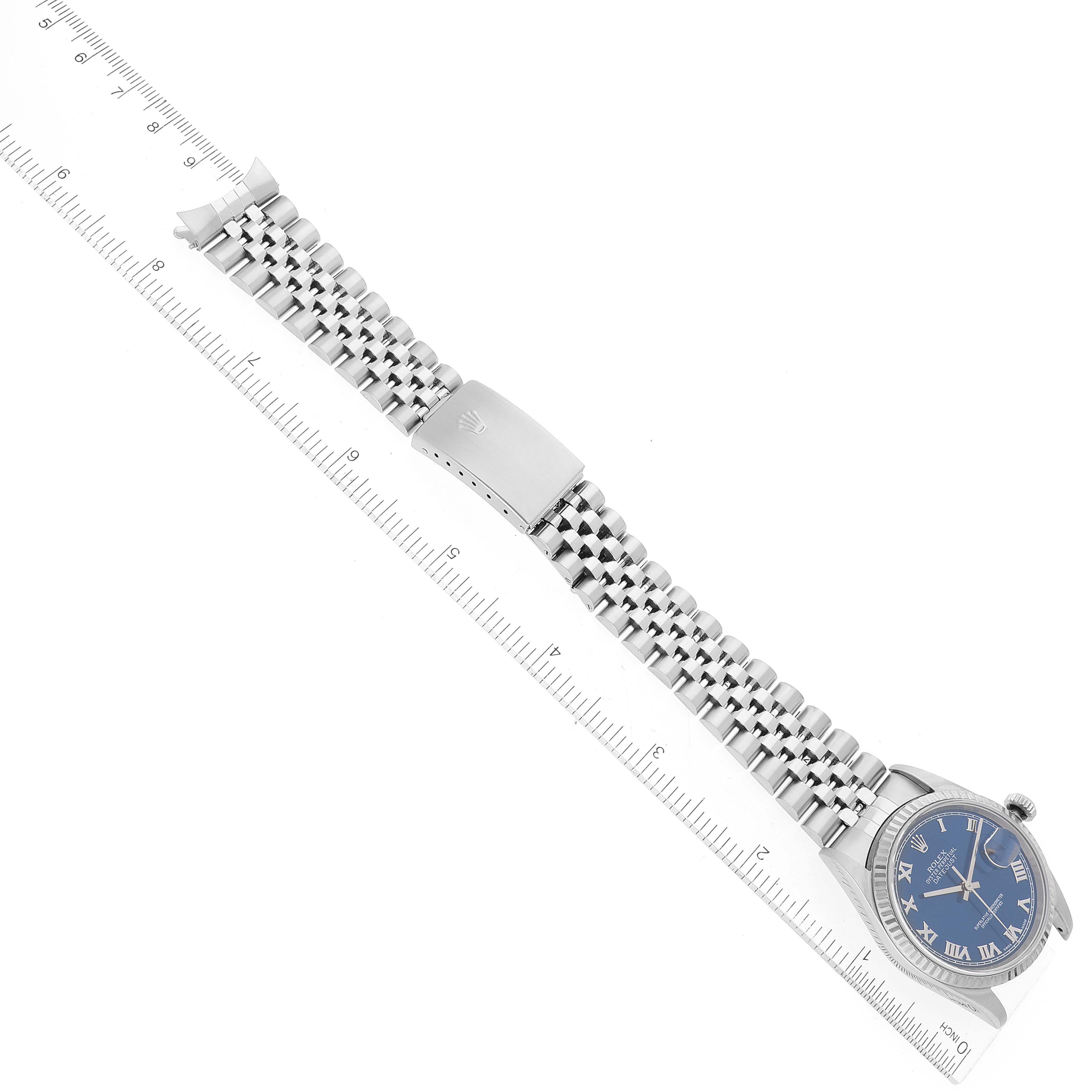 The image shows a Rolex Datejust 16234 Men's Stainless Steel Blue Dial 16234 Men's Stainless Steel Blue Dial watch laying flat with its bracelet fully extended alongside a ruler for measurement.