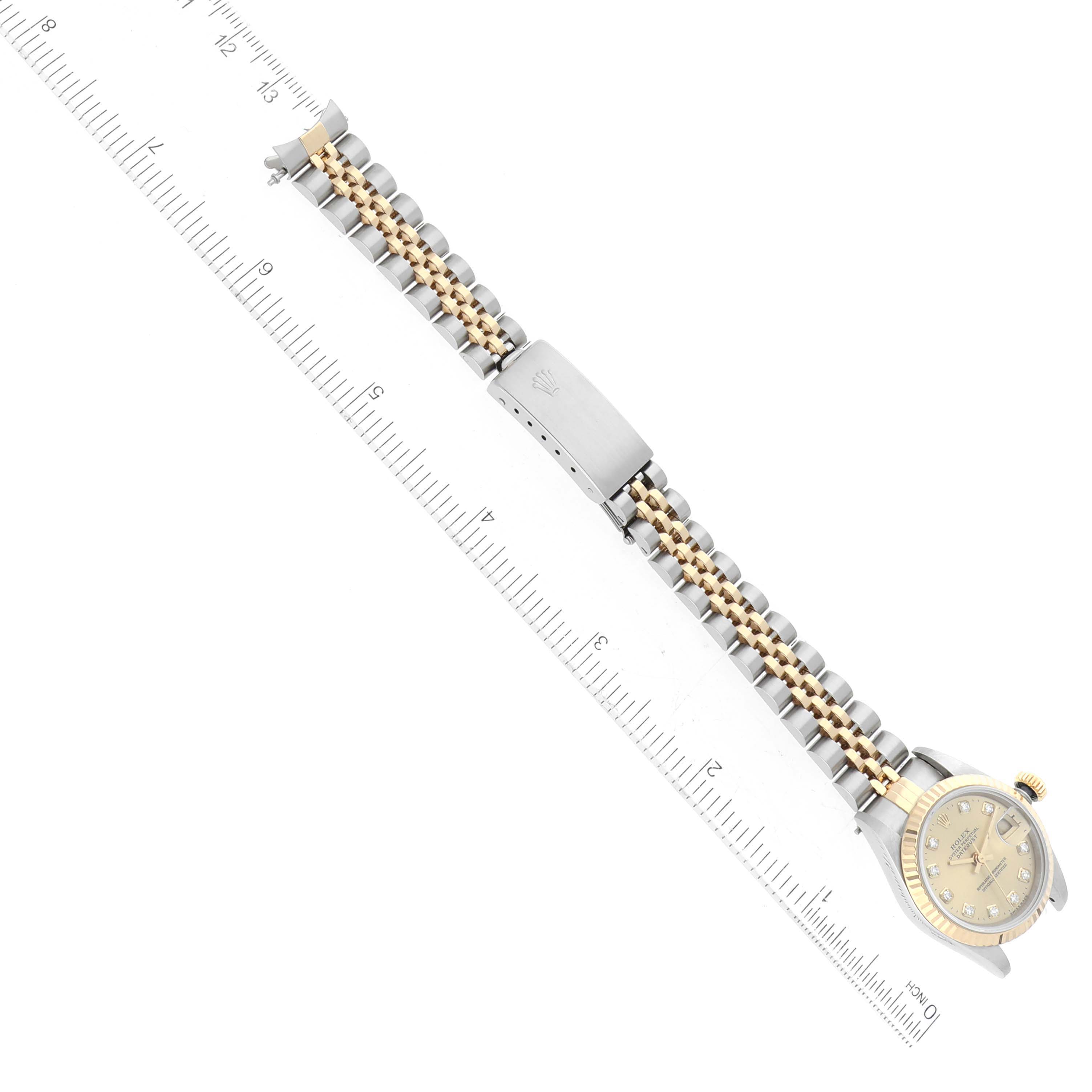 The image shows a Rolex Datejust 69173 Women's Steel and Gold (two tone) Champagne Dial 69173 Women's Steel and Gold (two tone) Champagne Dial watch laid flat with a ruler next to it, displaying the face, band, and clasp.