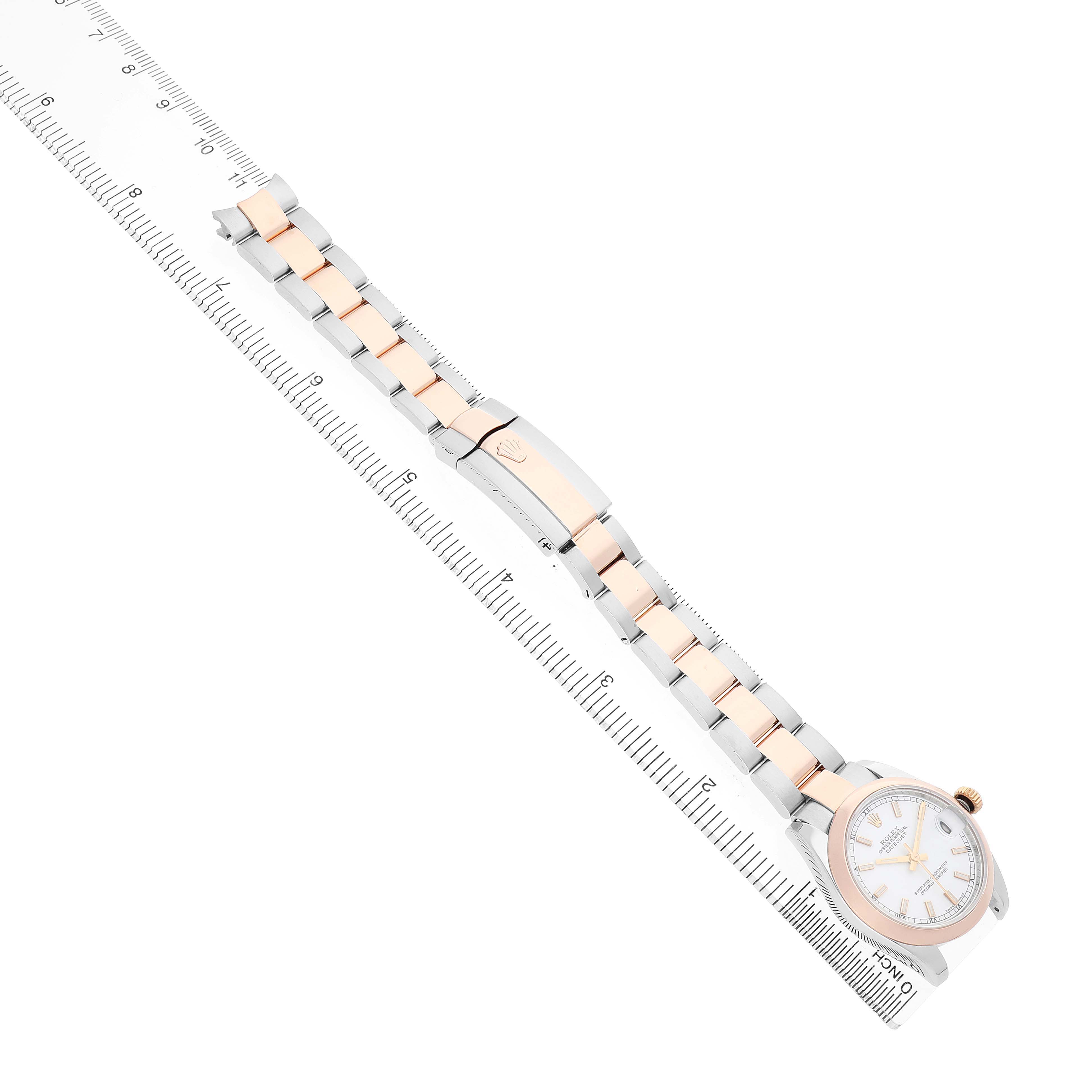 The Rolex Datejust 178241 Women's Steel and Gold (two tone) White Dial watch is shown from an overhead angle, displaying the dial and two-tone bracelet alongside a ruler.