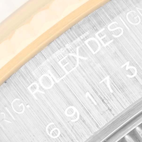 The image shows a close-up view of the engraved lettering on the side of the bezel and case of a Rolex Datejust 69173 Women's Steel and Gold (two tone) White Dial 69173 Women's Steel and Gold (two tone) White Dial watch.
