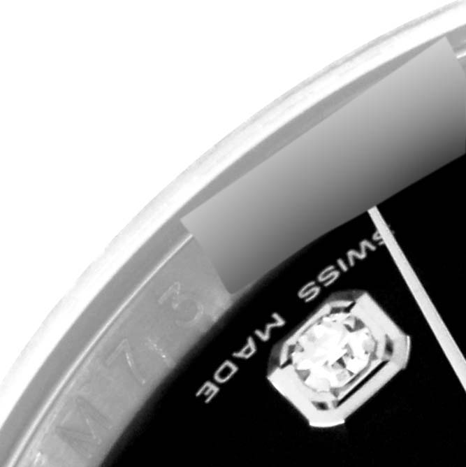 This close-up image of a Rolex Datejust 116234 Men's Stainless Steel Black Dial 116234 Men's Stainless Steel Black Dial watch shows part of the bezel, dial, and a diamond hour marker.