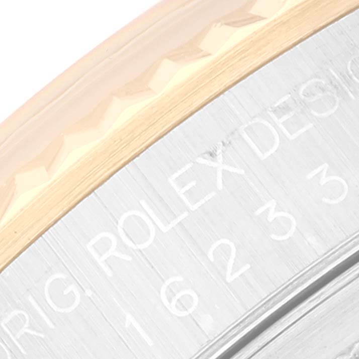 This image shows a close-up of the side of the bezel and case on a Rolex Datejust 16233 Men's Steel and Gold (two tone) Champagne Dial 16233 Men's Steel and Gold (two tone) Champagne Dial watch, including engraved text on the case.