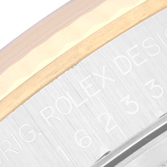 This close-up of a Rolex Datejust 16233 Men's Steel and Gold (two tone) Blue Dial 16233 Men's Steel and Gold (two tone) Blue Dial watch shows a section of the outer ring with engraved markings.
