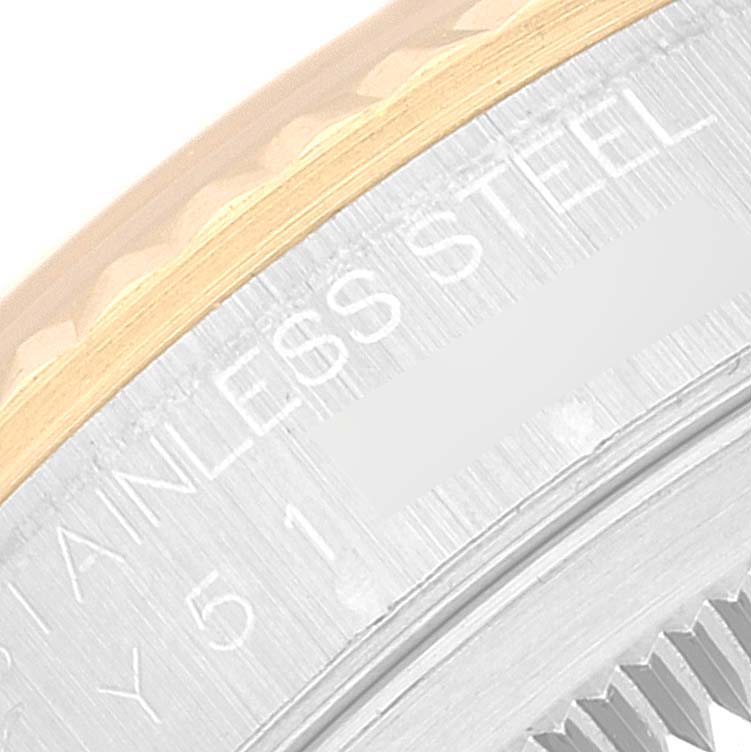 This close-up image of a Rolex Datejust 16233 Men's Steel and Gold (two tone) White Dial 16233 Men's Steel and Gold (two tone) White Dial watch shows part of the fluted bezel and the engraved steel casing. 