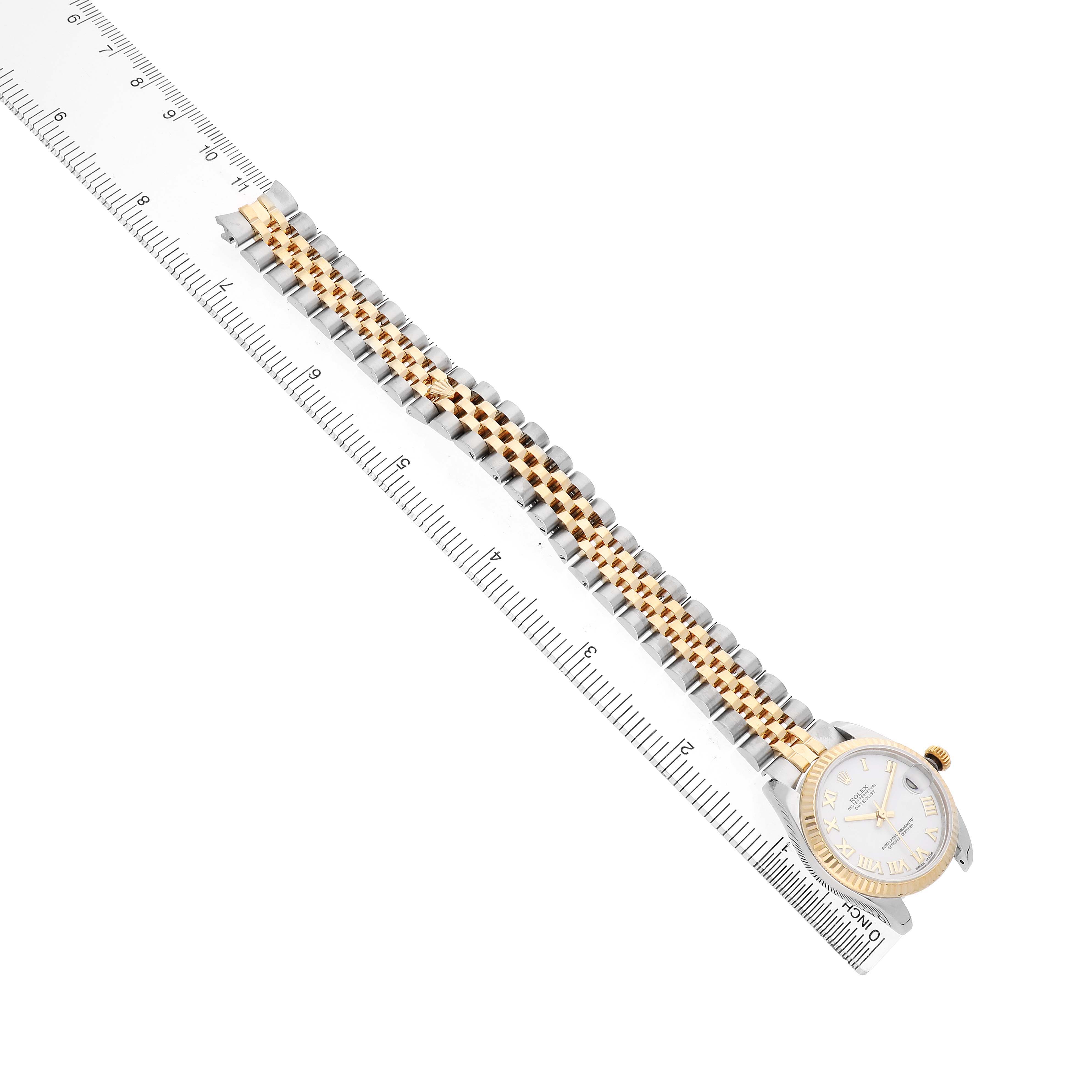 The Rolex Datejust 69173 Women's Steel and Gold (two tone) White Dial watch is shown from above, highlighting the two-tone bracelet and face next to a ruler for scale.