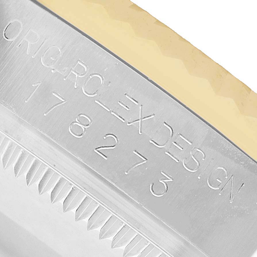The image shows a close-up of the side engraving on the bezel of a Rolex Datejust 69173 Women's Steel and Gold (two tone) White Dial watch.