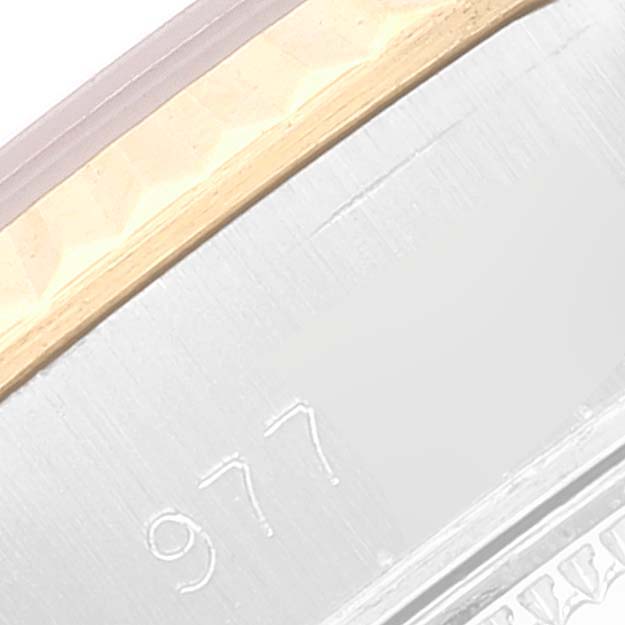 The image shows a close-up of the edge of a Rolex Datejust 69173 Women's Steel and Gold (two tone) Silver Dial 69173 Women's Steel and Gold (two tone) Silver Dial watch, highlighting its engraved serial number and part of the bezel.