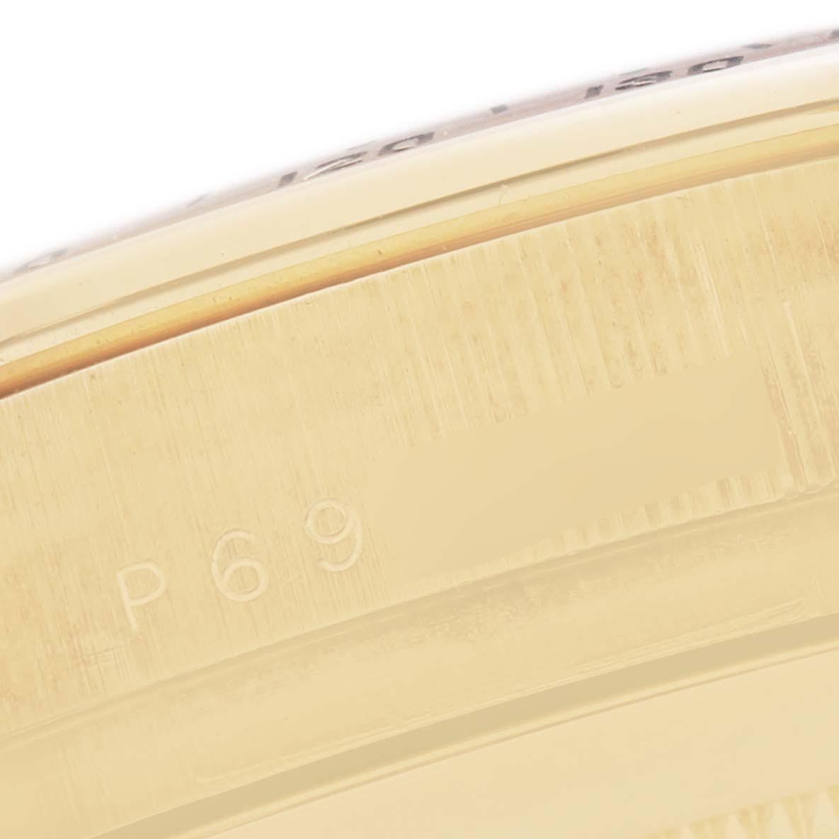 The image shows a close-up of the side of a Rolex Daytona 116528 Men
s Yellow Gold Black Dial 116528 Men
s Yellow Gold Black Dial watch, revealing part of the bezel and engraving details.